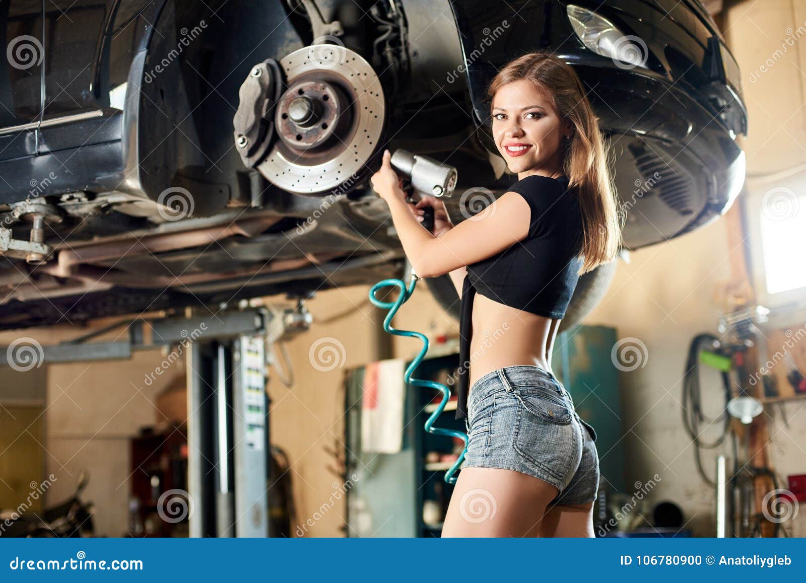 beautiful girl fixing the bottom of the car.