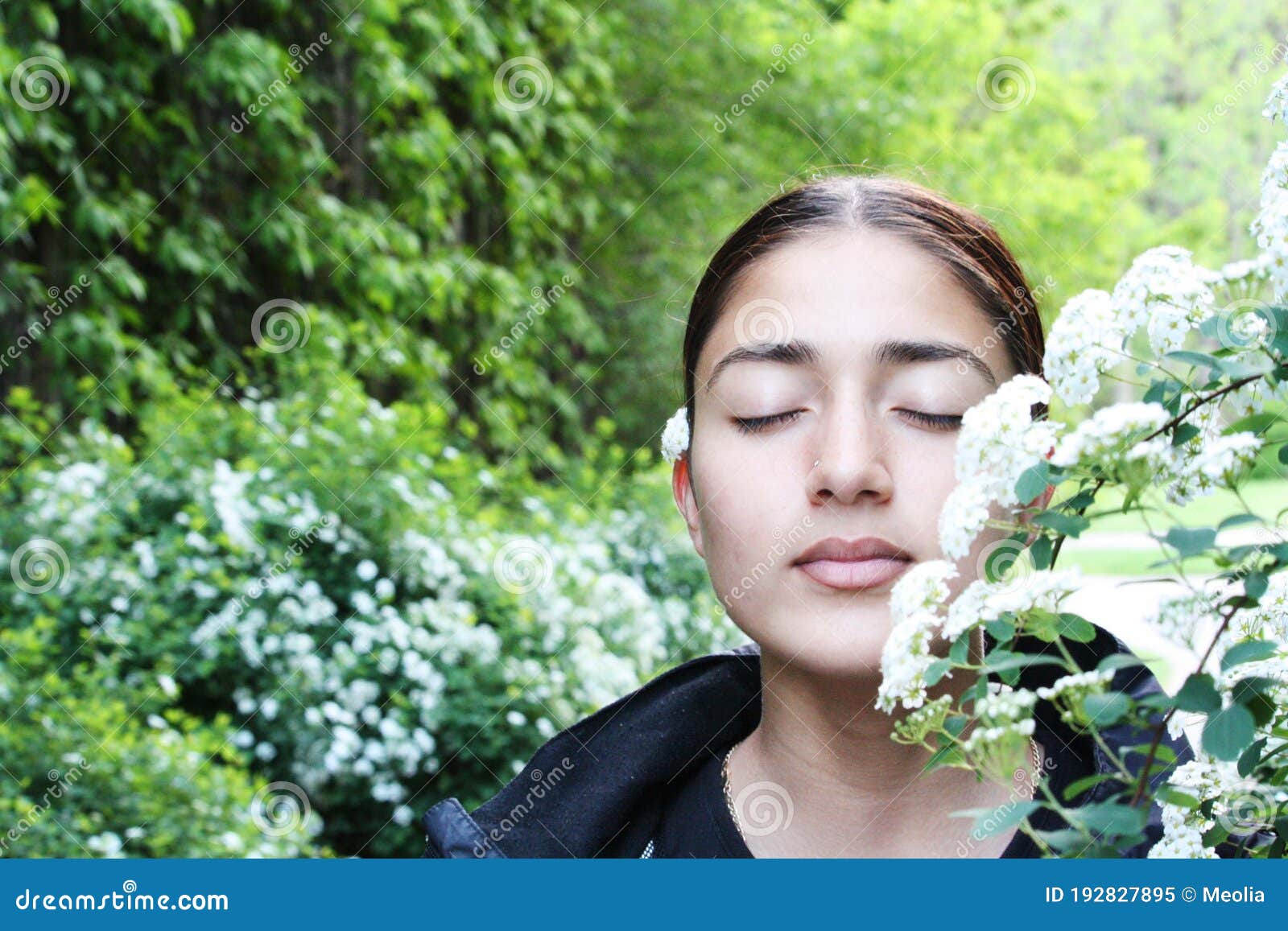 Beautiful Girl Surrounded by Green Plants and White Flowers Stock Image