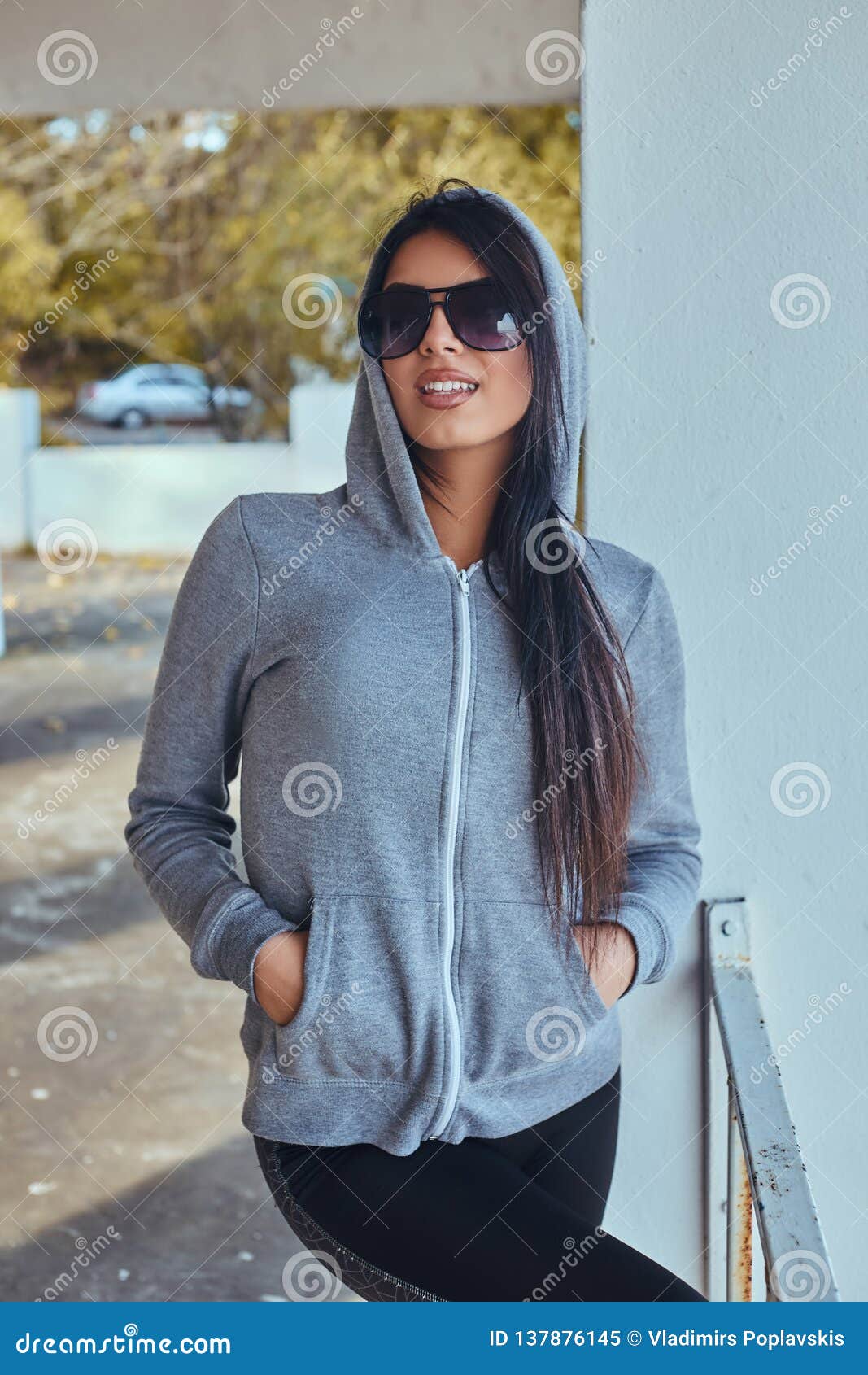 Portrait of a Beautiful Girl with Tanned Skin Wearing a Gray Hoodie and ...