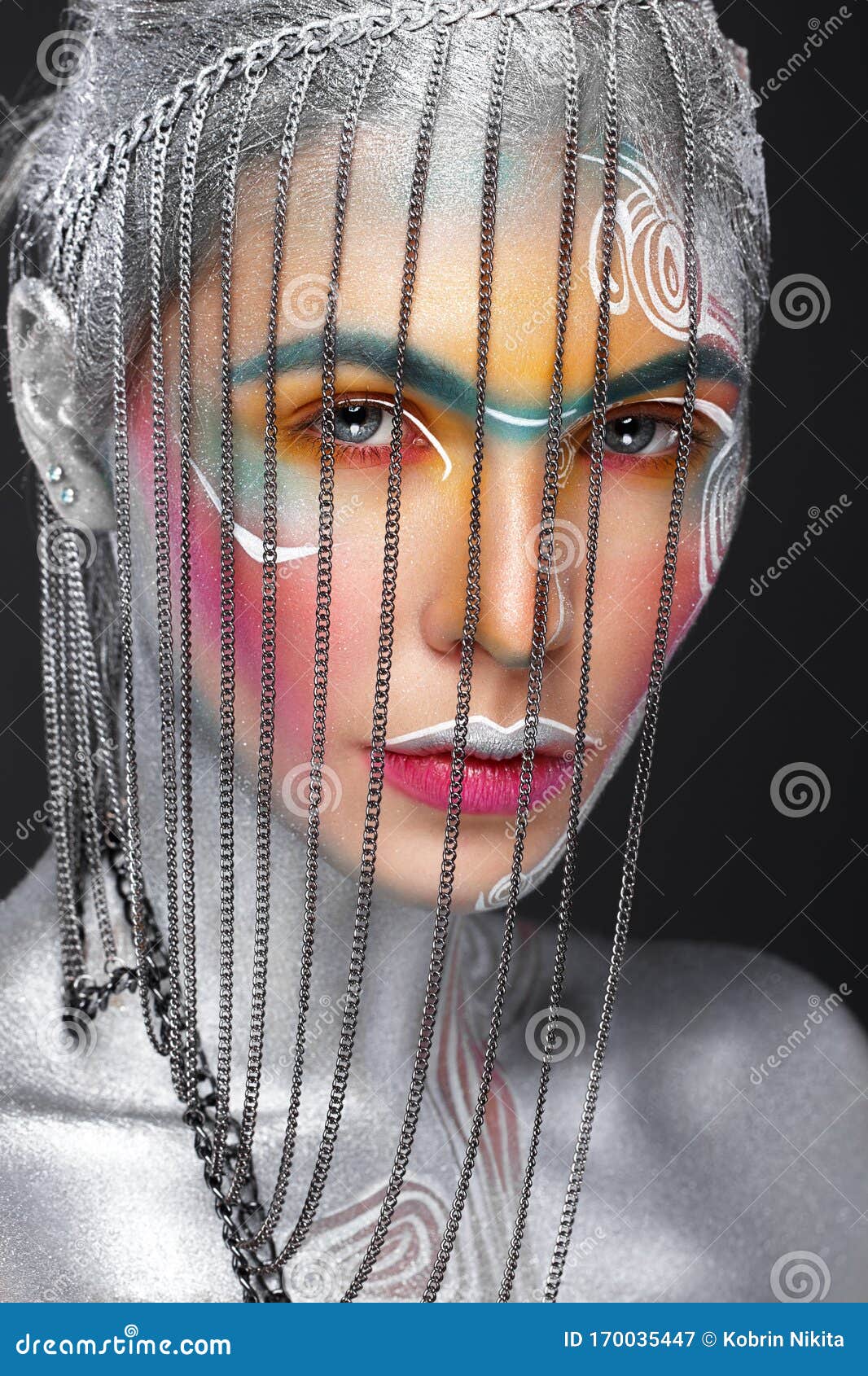 beautiful girl in an unusual winter look with colorful face. creative make- up. art look