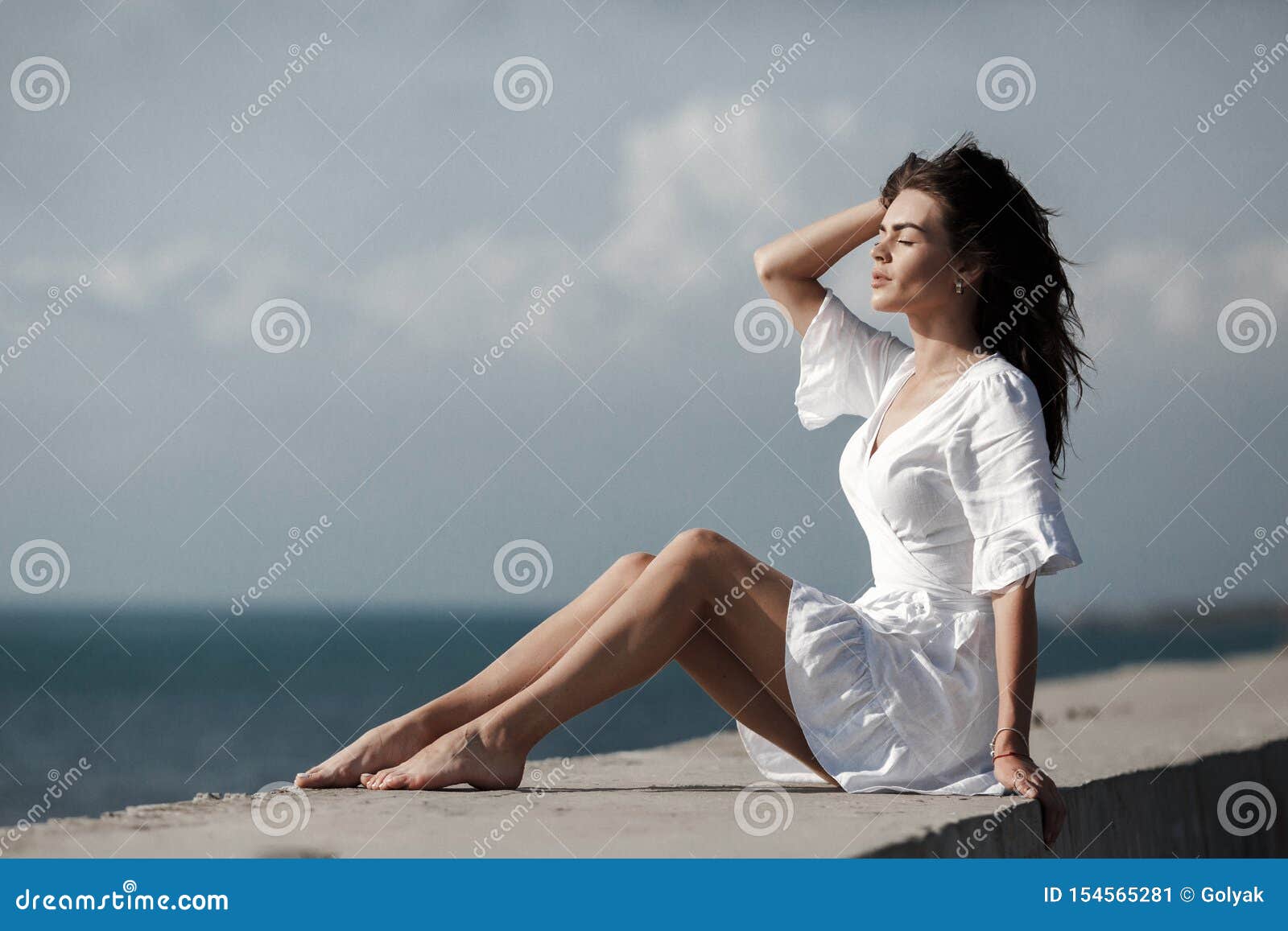 Beautiful Woman in White Summer Dress Sitting Alone by the Sea in ...