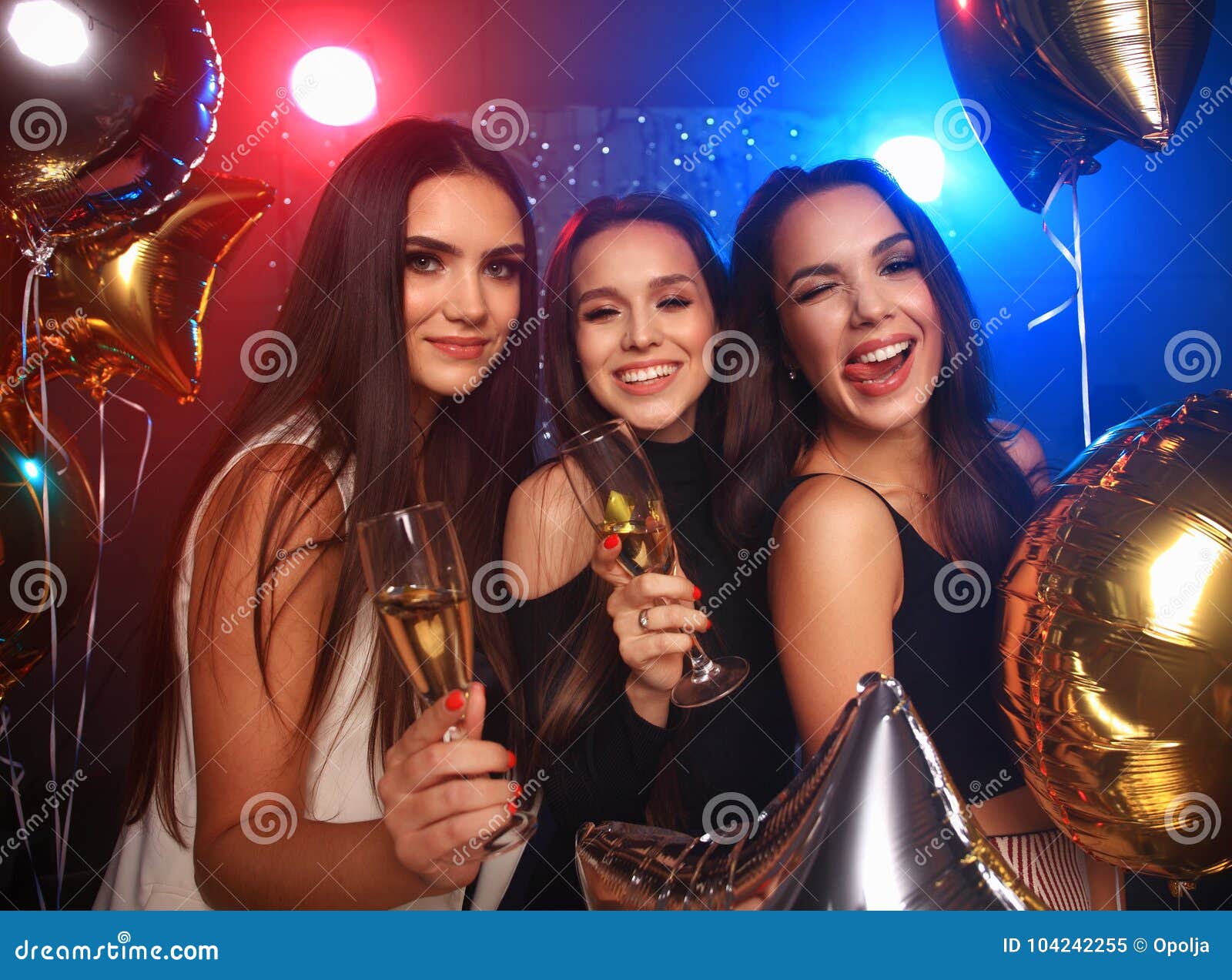 Party, holidays, celebration, nightlife and people concept - smiling friends dancing in club. Beautiful girls having party fun, drinking champagne. Holidays, celebration, nightlife and people concept - smiling friends dancing in club