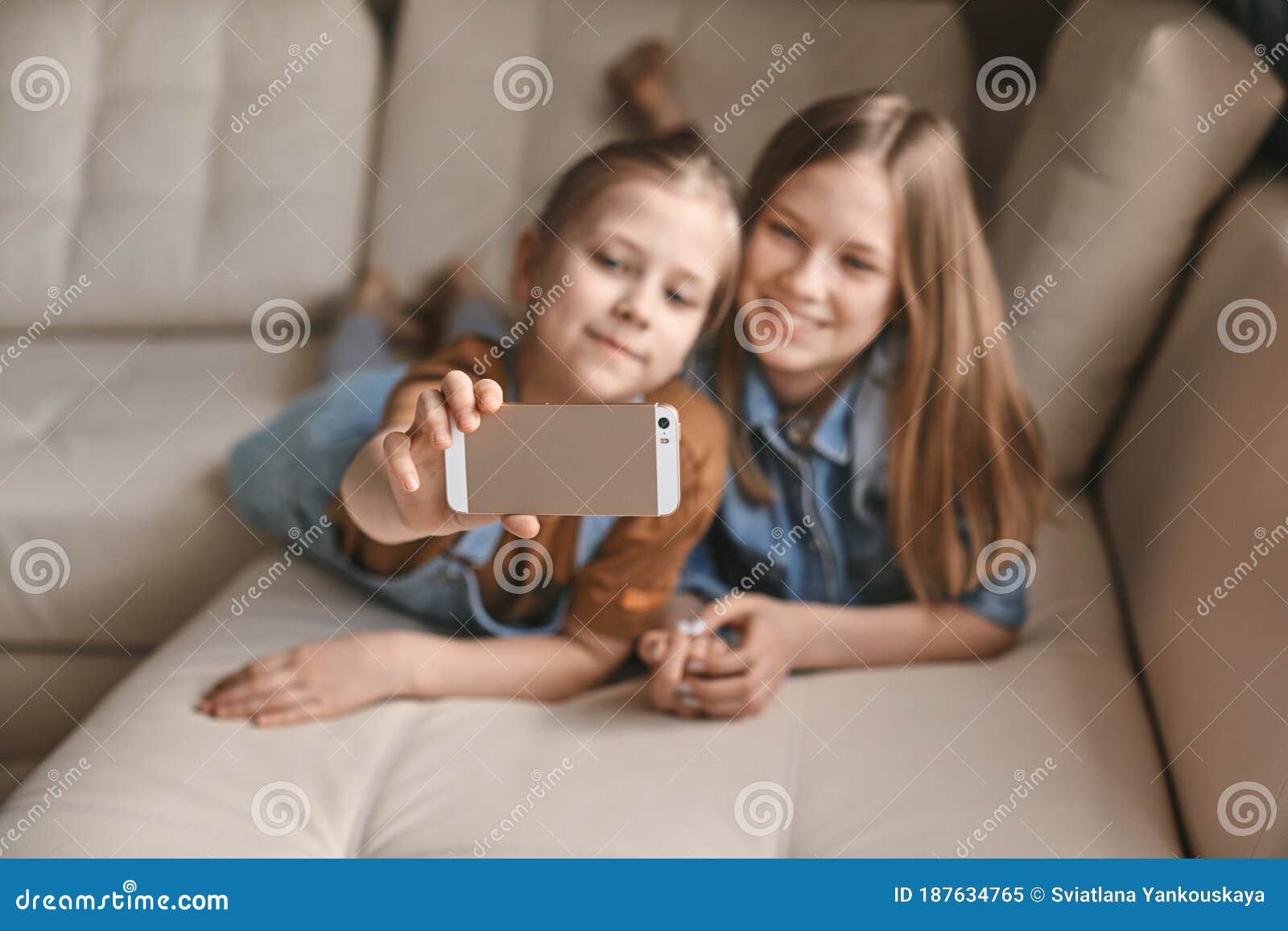 Beautiful Girls Take Selfies on Their Phone while Lying on the Sofa ...