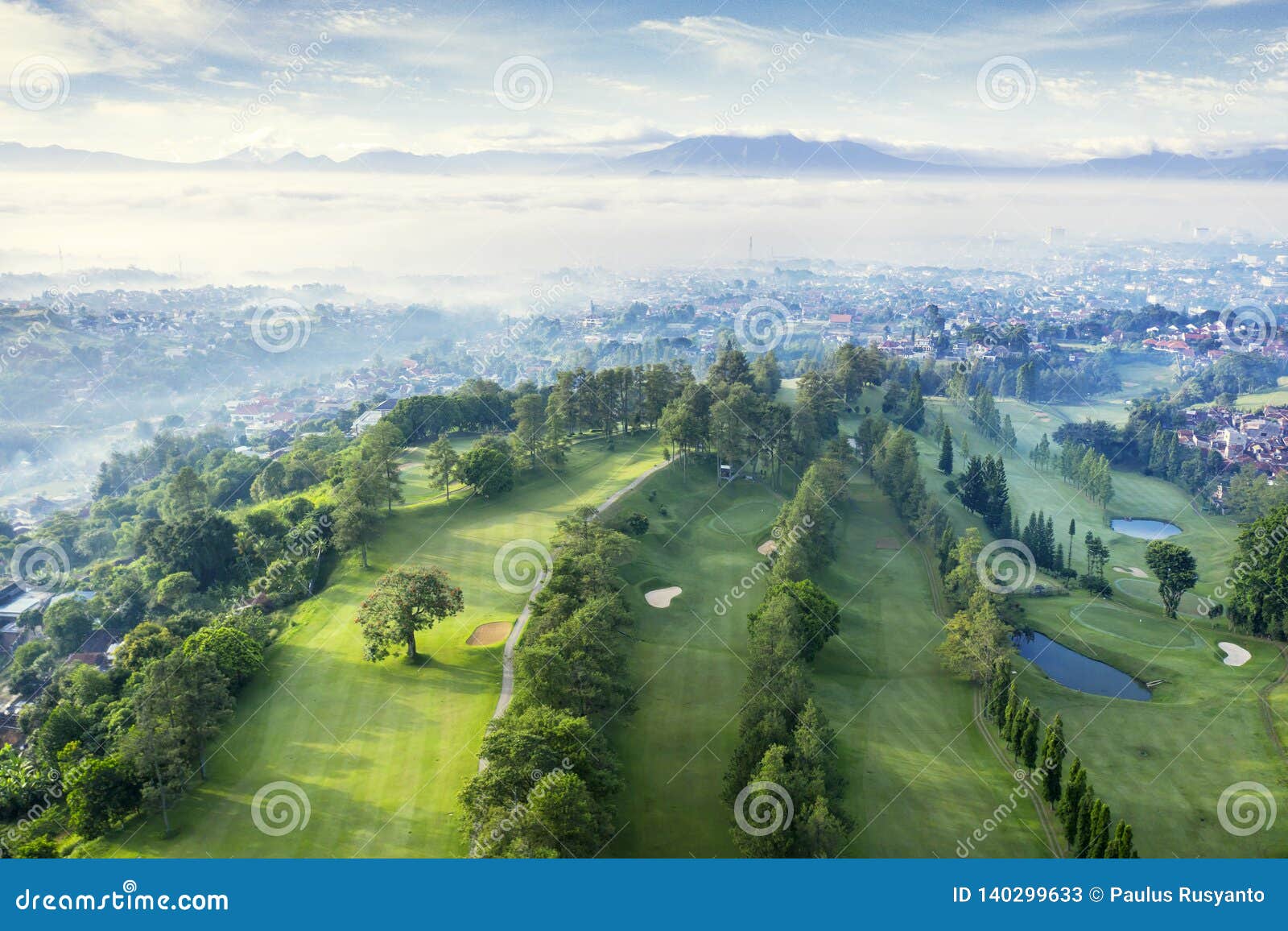 beautiful golf course with misty bandung cityscape