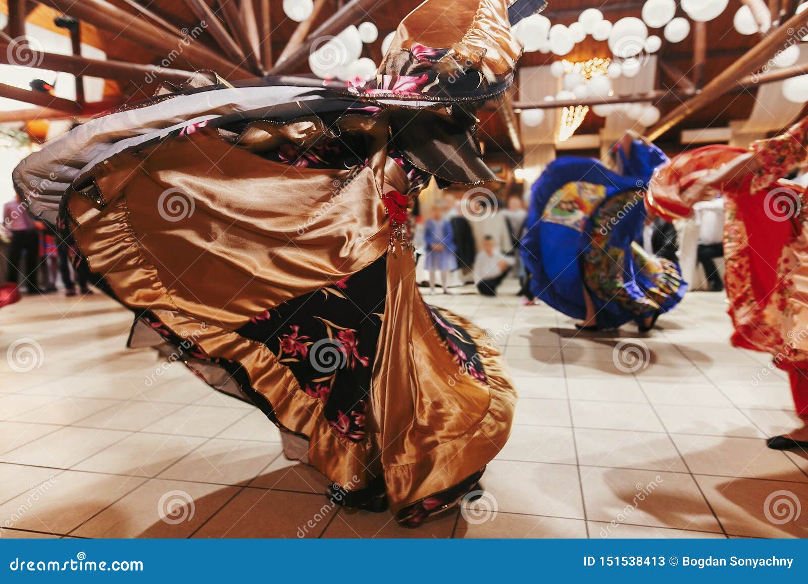 Gypsy dance festival, Woman performing romany dance and folk songs in  national clothing. Beautiful roma gypsy girls dancing in traditional floral  dress at wedding reception in restaurant Stock Photo