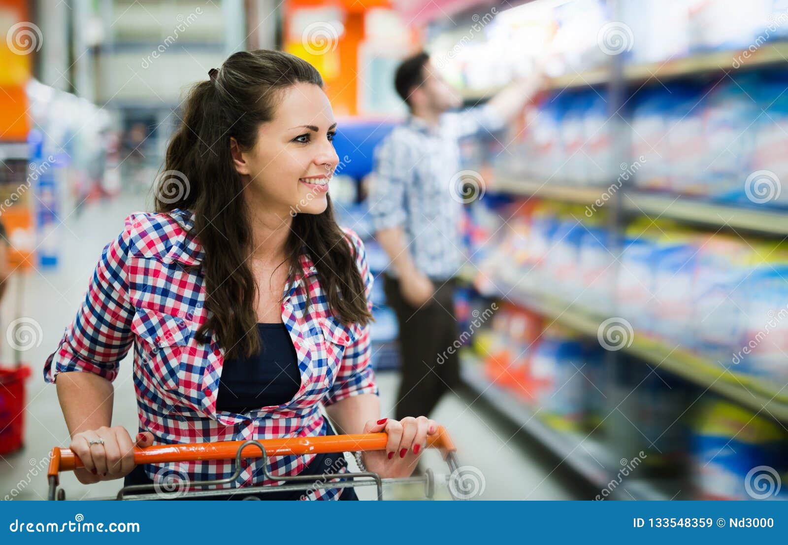 beautiful happy female shopper in supermarket