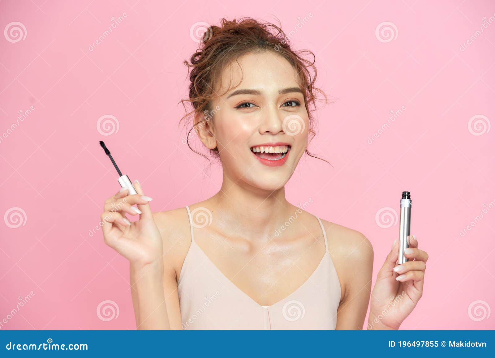beautiful happy girl apply mascara facial cosmetics