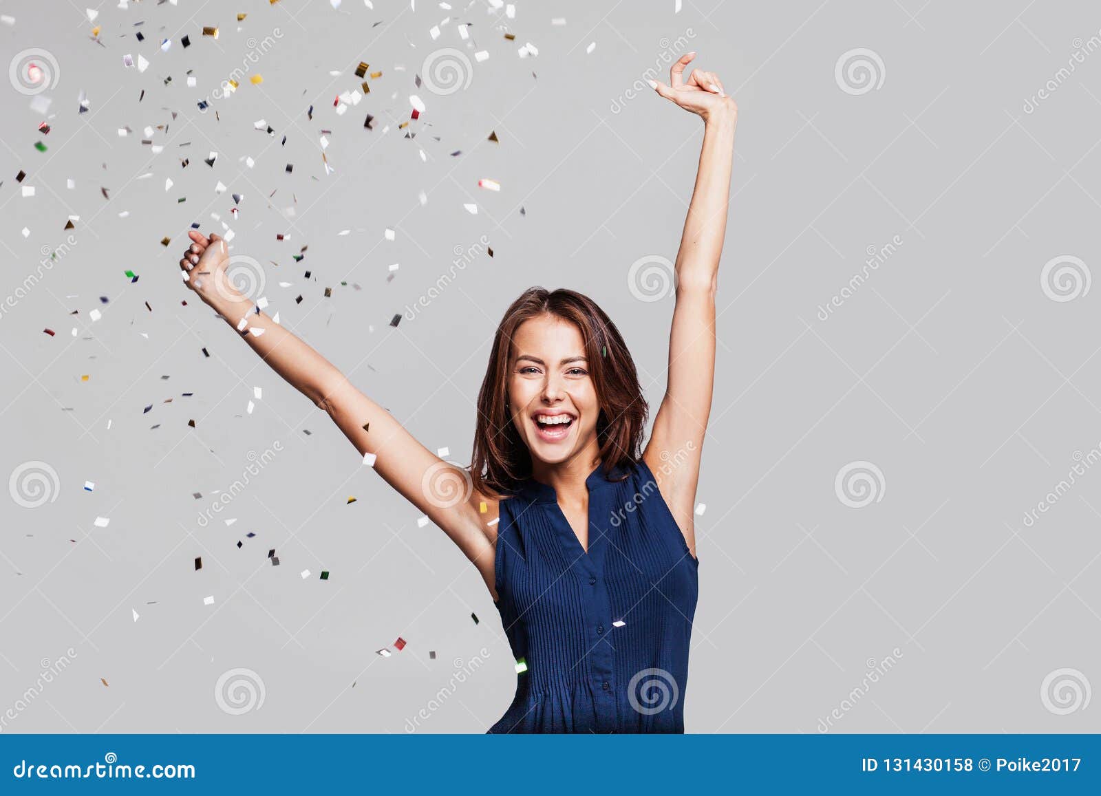 beautiful happy woman at celebration party with confetti falling everywhere on her. birthday or new year eve celebrating concept