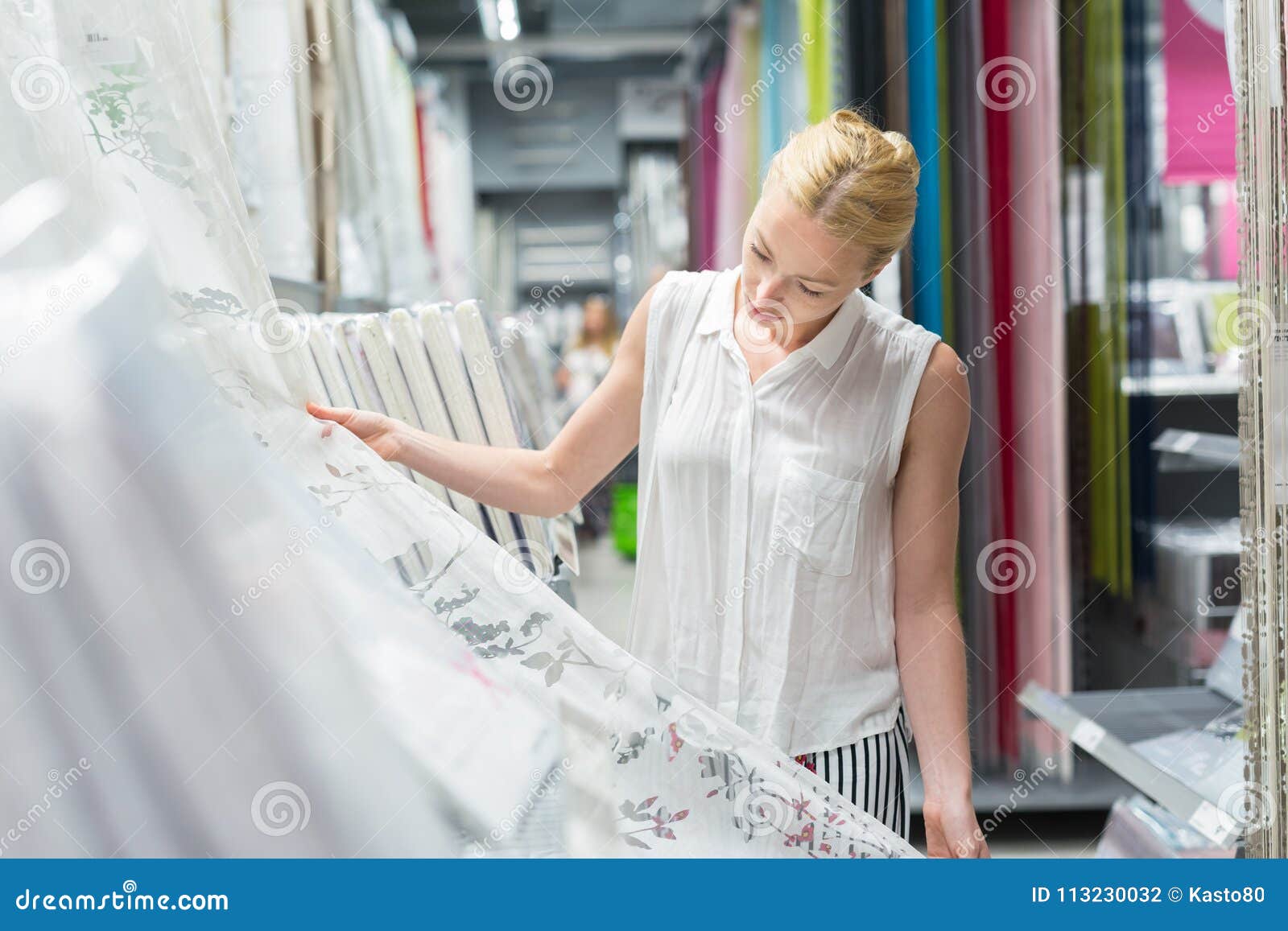 beautiful housewife buying white curtains in home decor furnishings store.