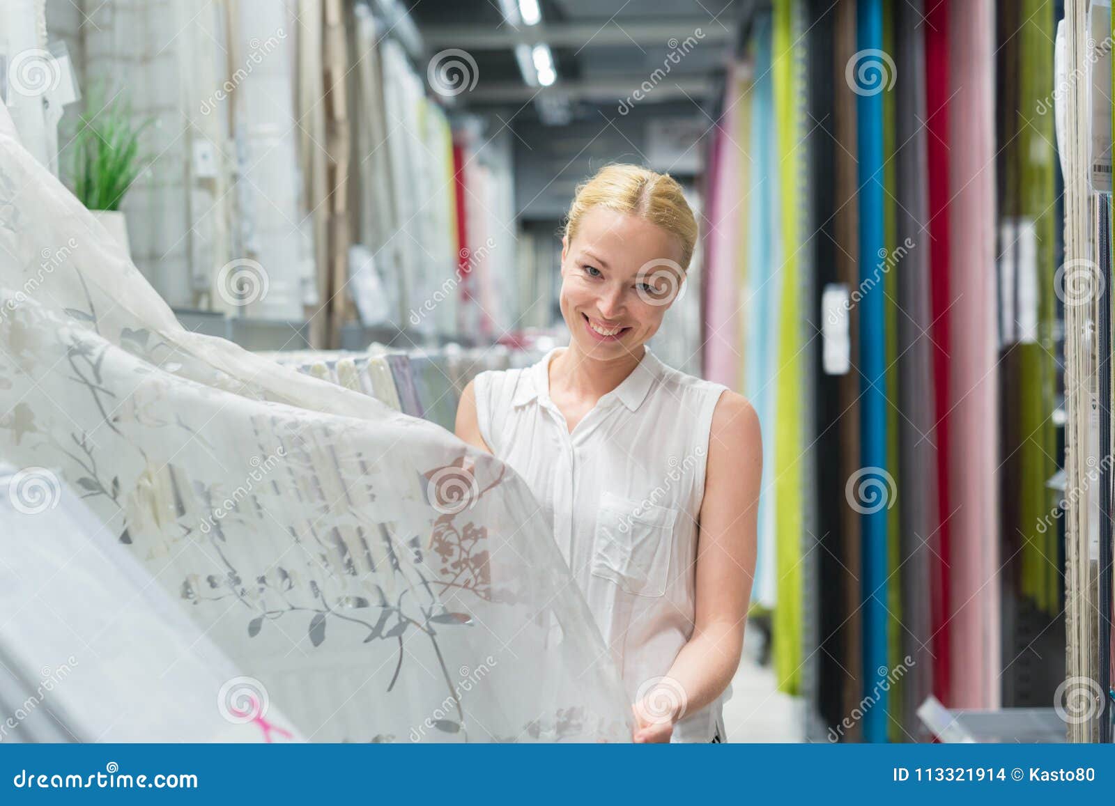 beautiful housewife buying white curtains in home decor furnishings store.