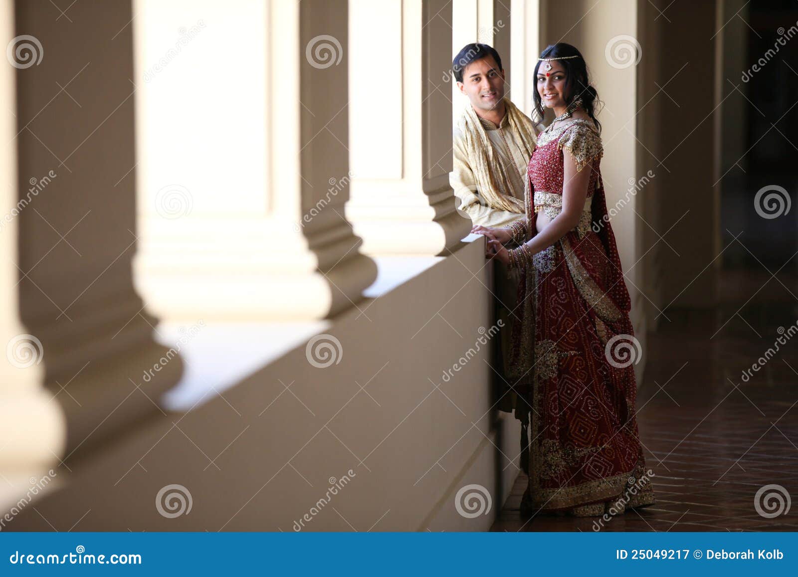 AI generated Indian groom dressed in white Sherwani and red hat with  stunning bride in red lehenga stand and hold each hands walking outside  34797755 Stock Photo at Vecteezy