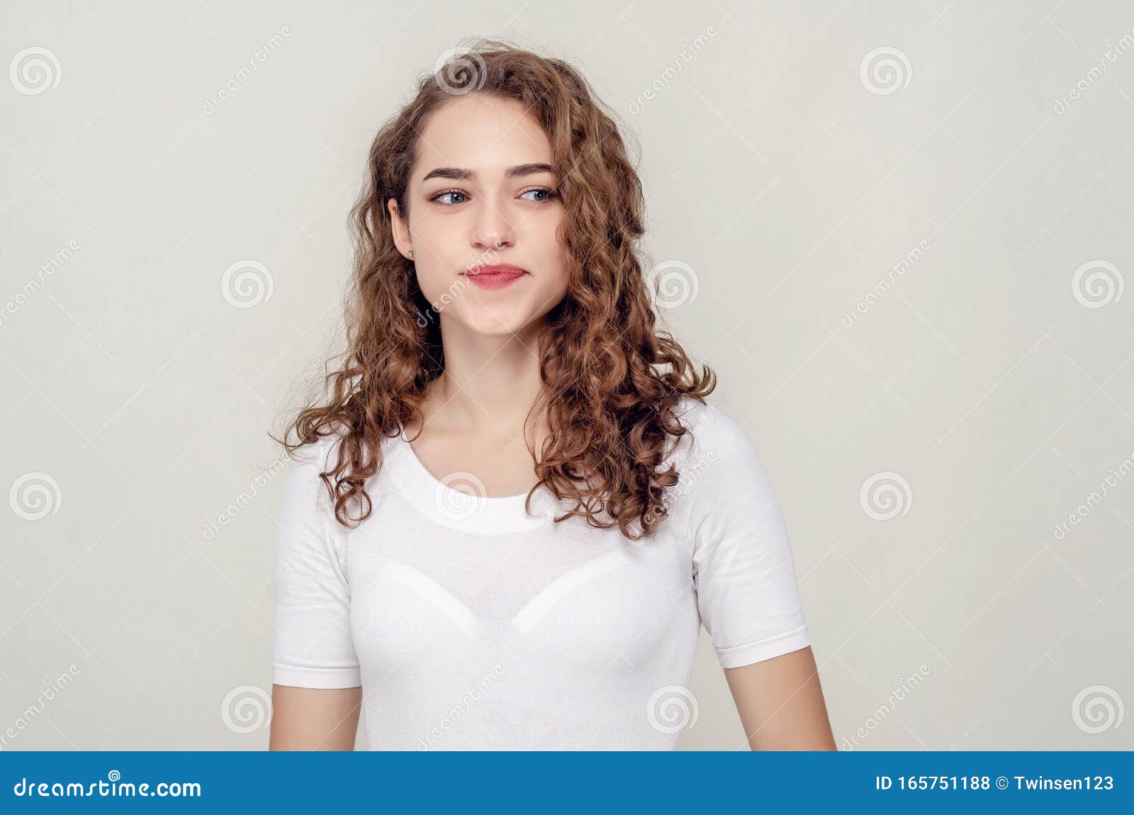 Beautiful Ironic Girl Up To the Waist on a Beige Background Looks Away ...