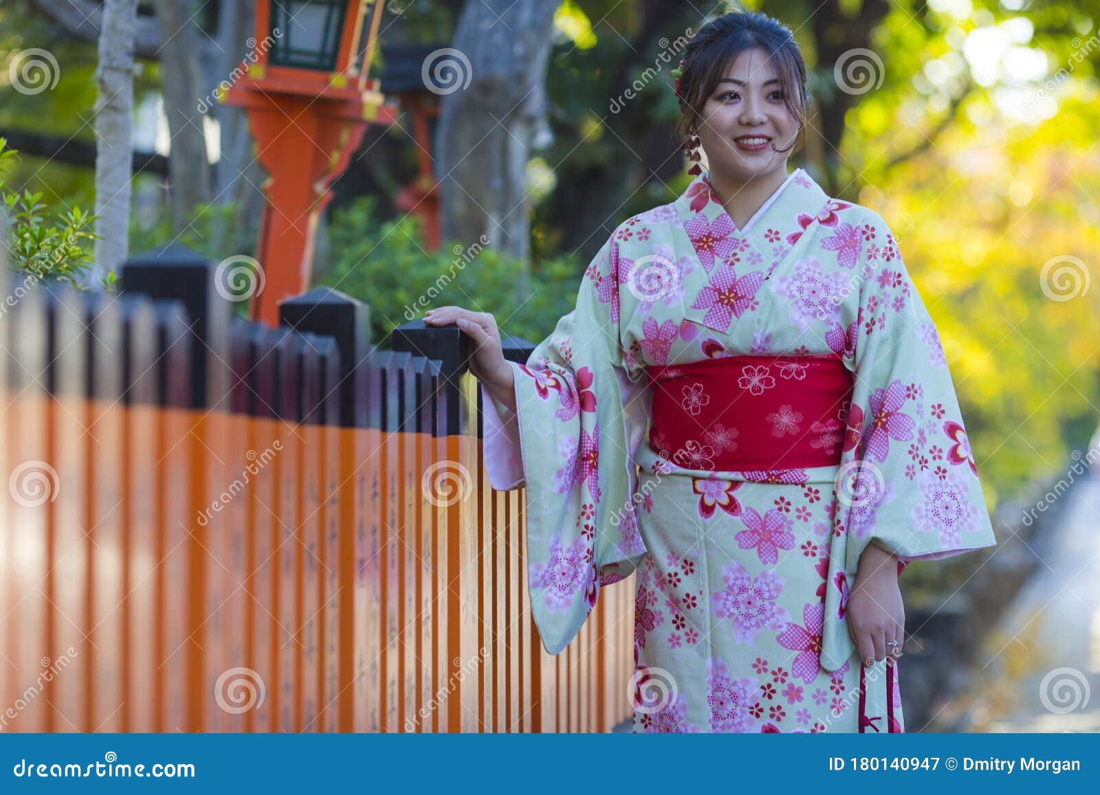 Beautiful Japanese Geisha Girl Posing In Floral Silk Kimono In Traditional Environment In Kyoto