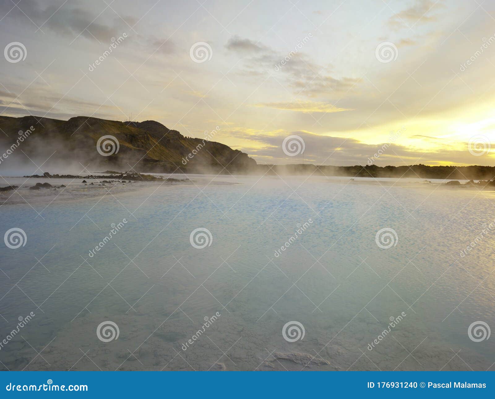 beautiful landscape of blue lagoon thermal bath in iceland with steam in a cold atmosphere in sunset with a dramatic sky