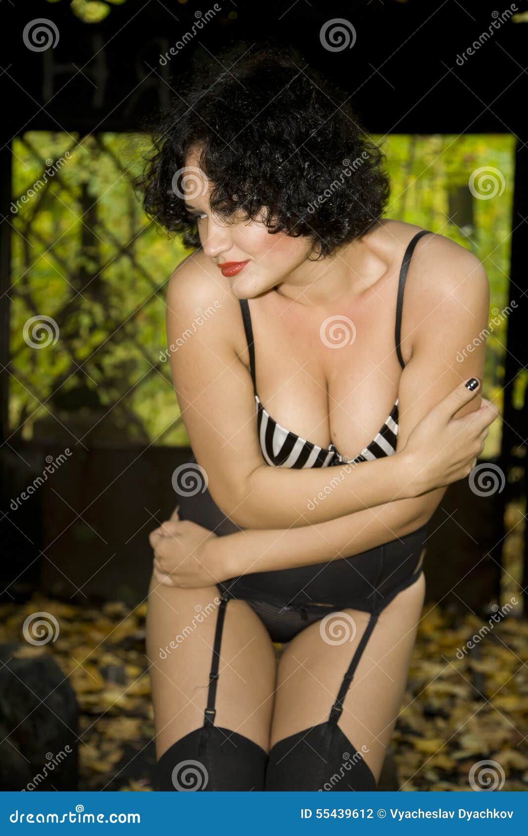 Beautiful Large Full Brunette Girl in Black Lingerie, Stockings and Corsage in Old Ruins Metal Decorated Public Buildings pic