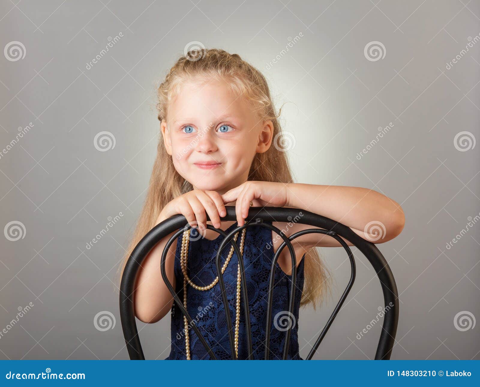 Beautiful Little Girl Dressed in a Dark Dress and Jewelry on Gray Stock ...