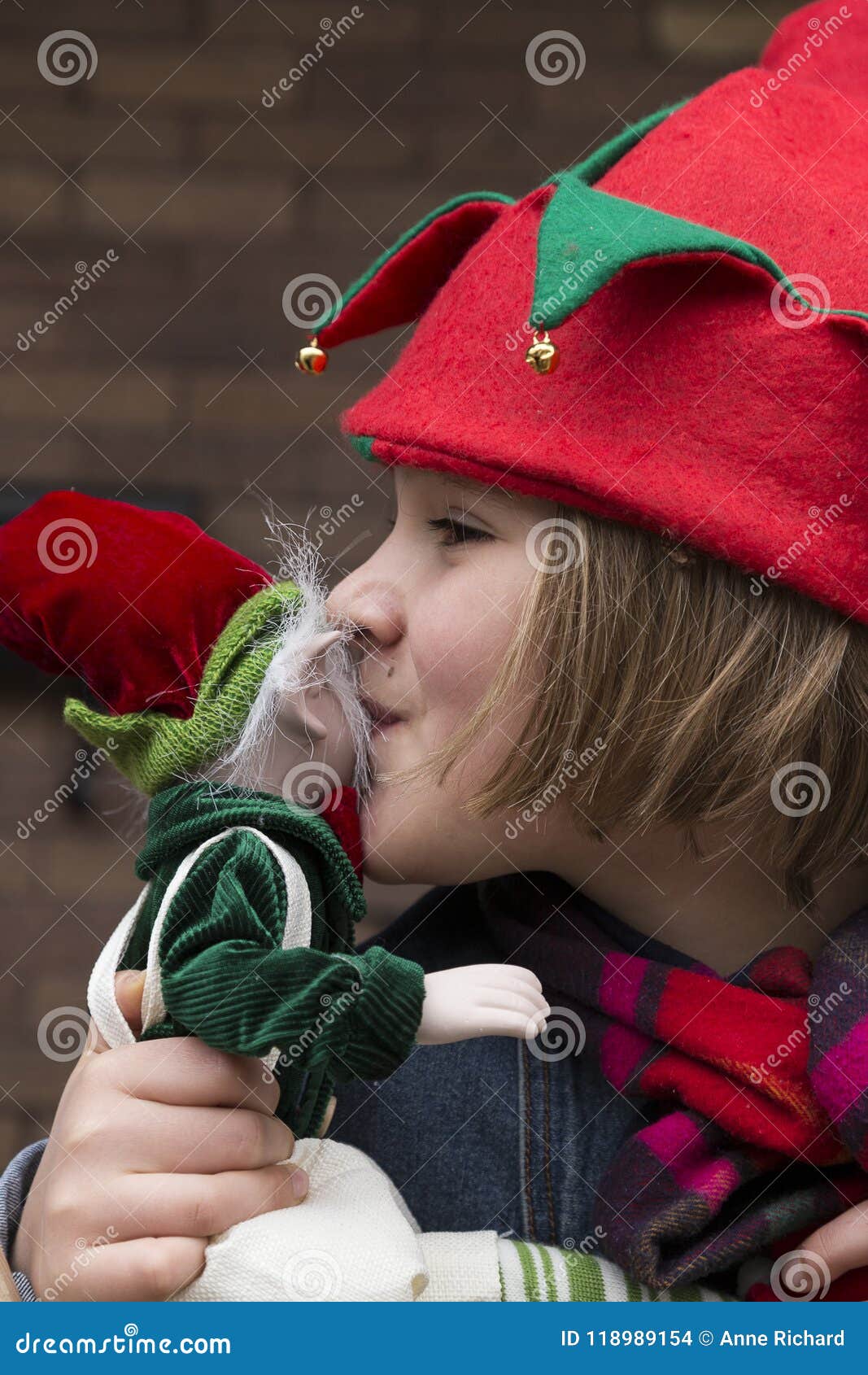 Beautiful Little Girl With Elf Hat Kissing Elf Toy Stock
