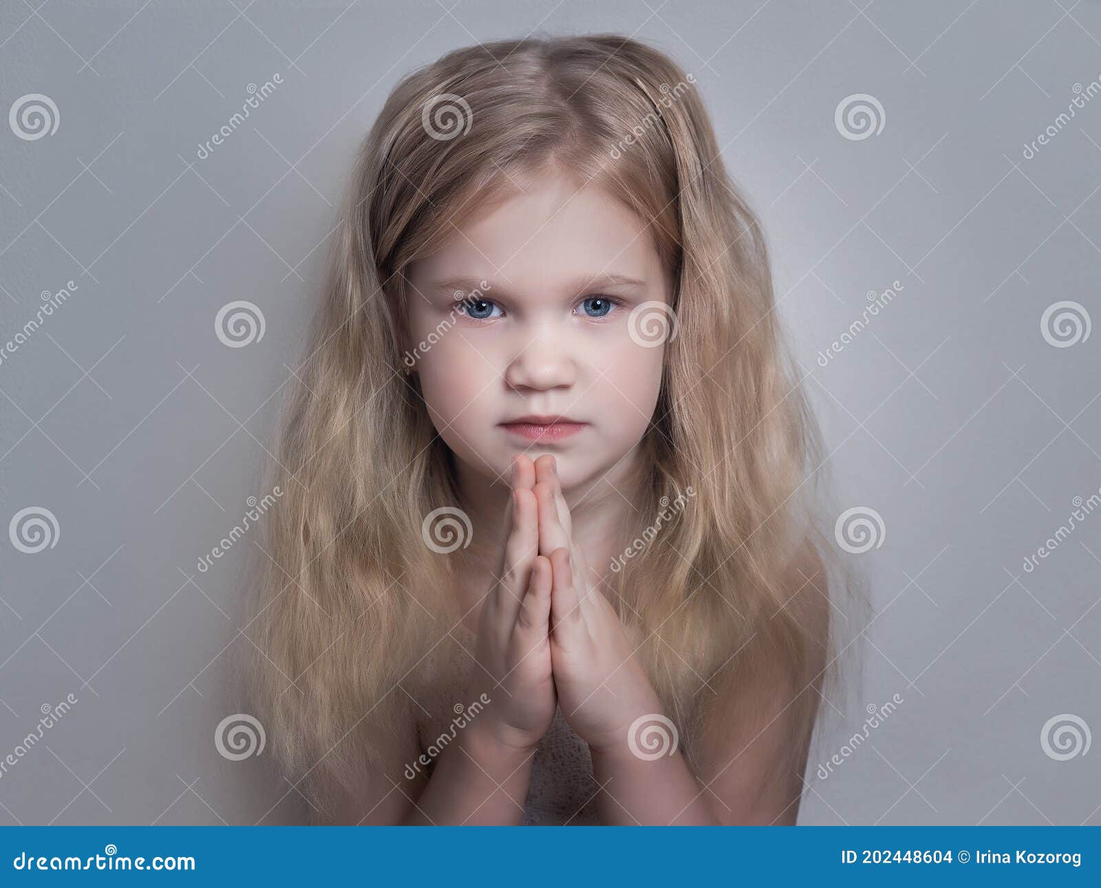 beautiful little girl folded her hands in a prayerful gesture.