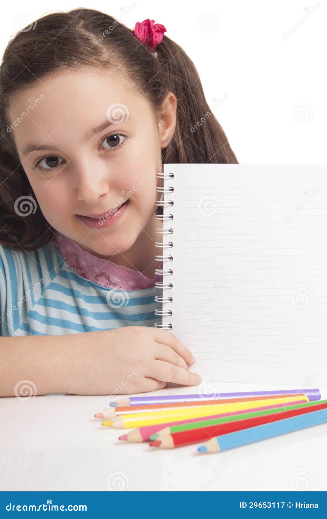 beautiful little girl showing empty space on notebook
