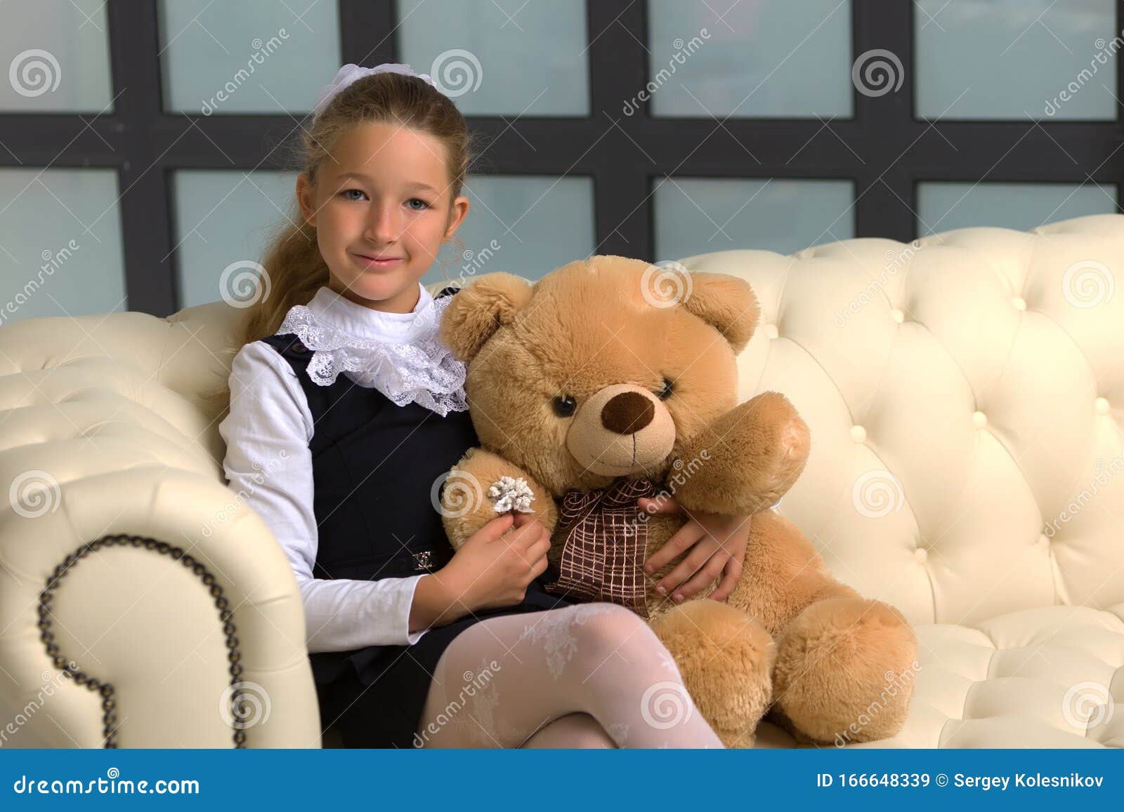 Little Girl on Sofa Hugging Teddy Bear. Stock Image - Image of ...