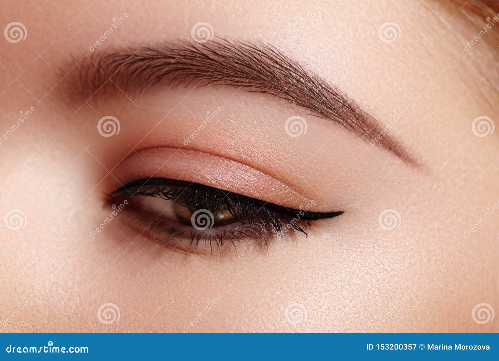 beautiful macro shot of female eye with classic eyeliner makeup. perfect  of eyebrows. cosmetics and make-up