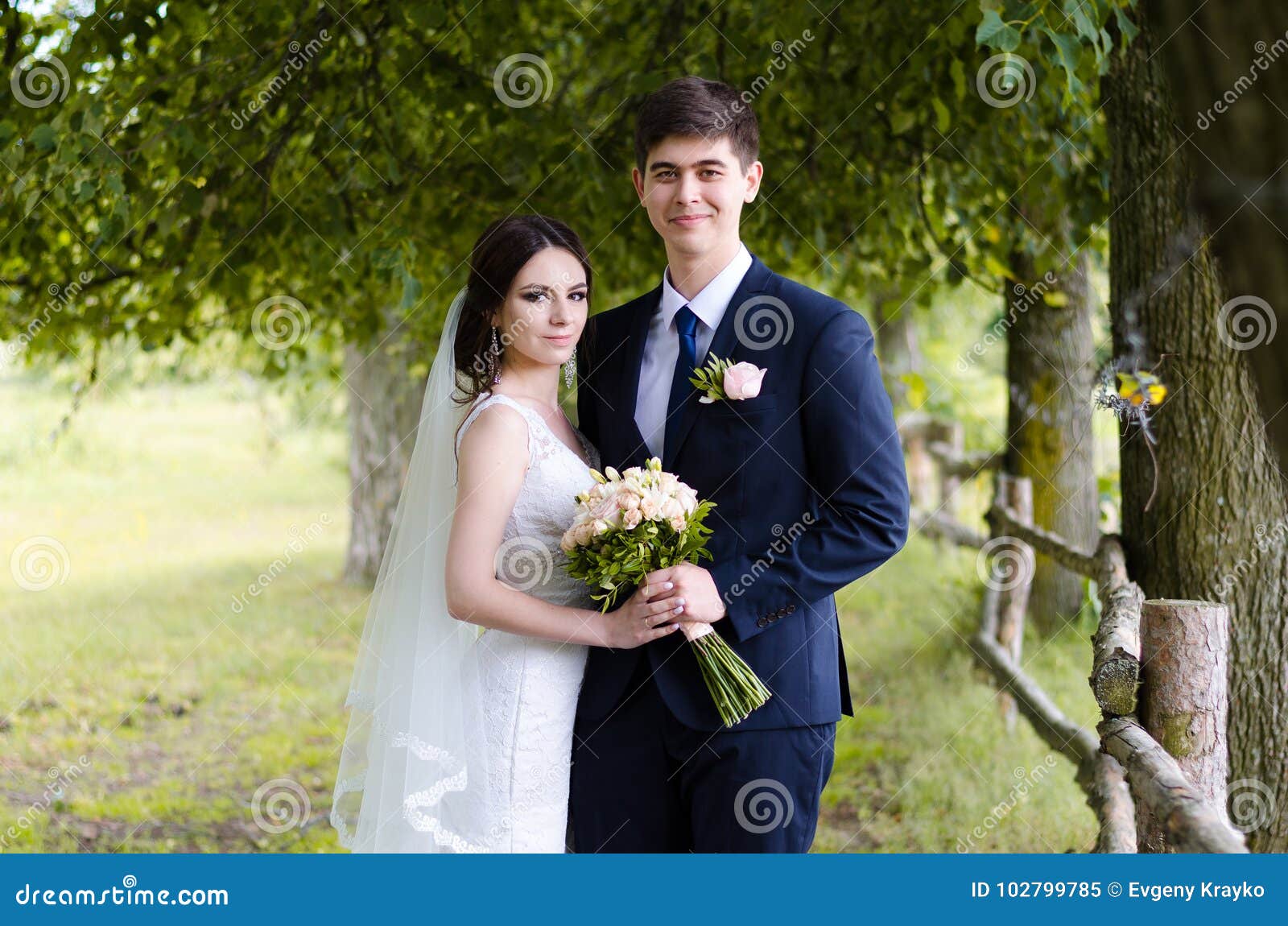 A Beautiful Married Couple in Wedding Dresses, Posing for a Photo Shooting  in an Belarusian Village Near the Fence, with a Wedding Stock Image - Image  of dress, female: 102799785