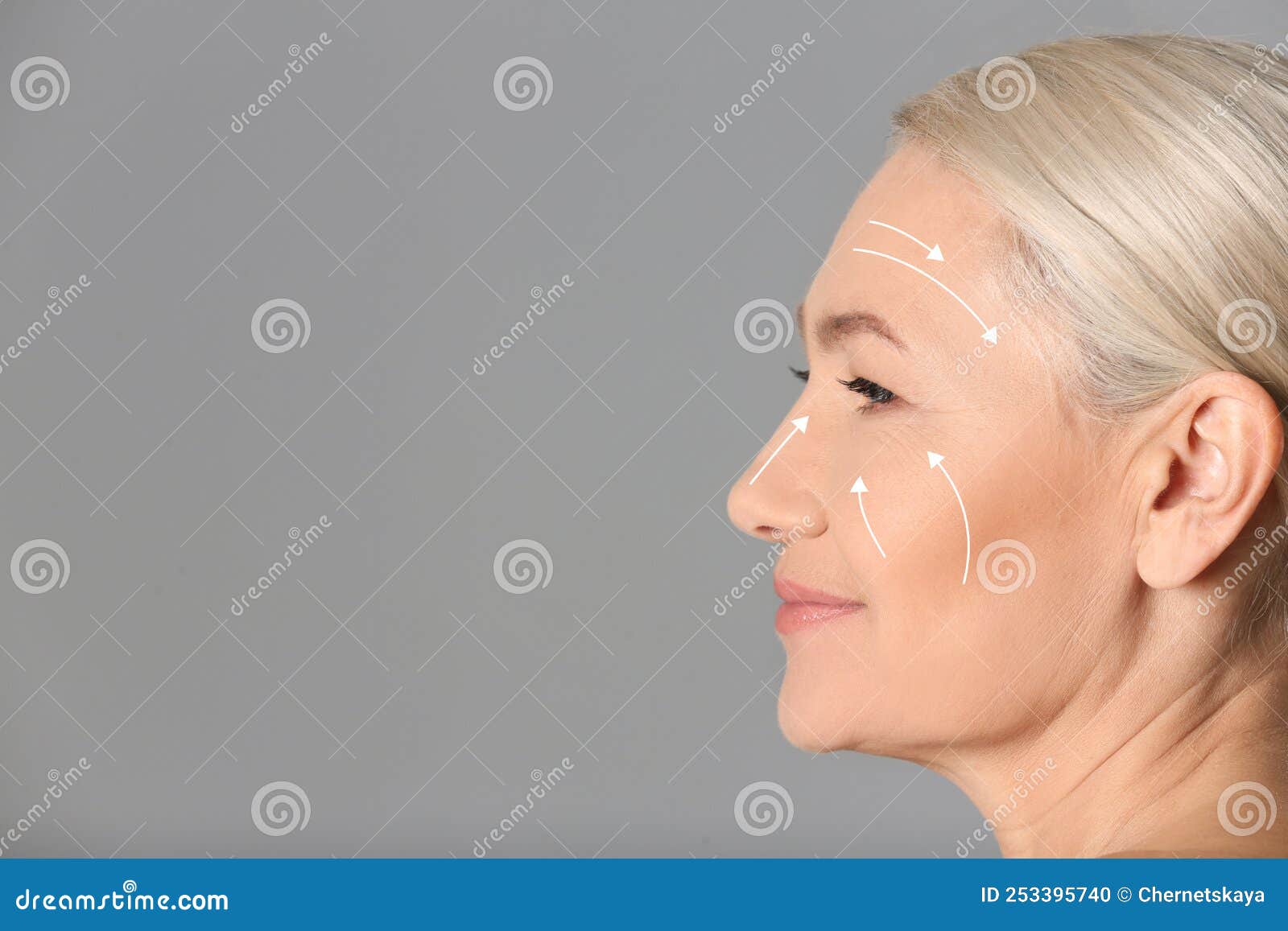 beautiful mature woman after facelift cosmetic surgery procedure on grey background. space for text