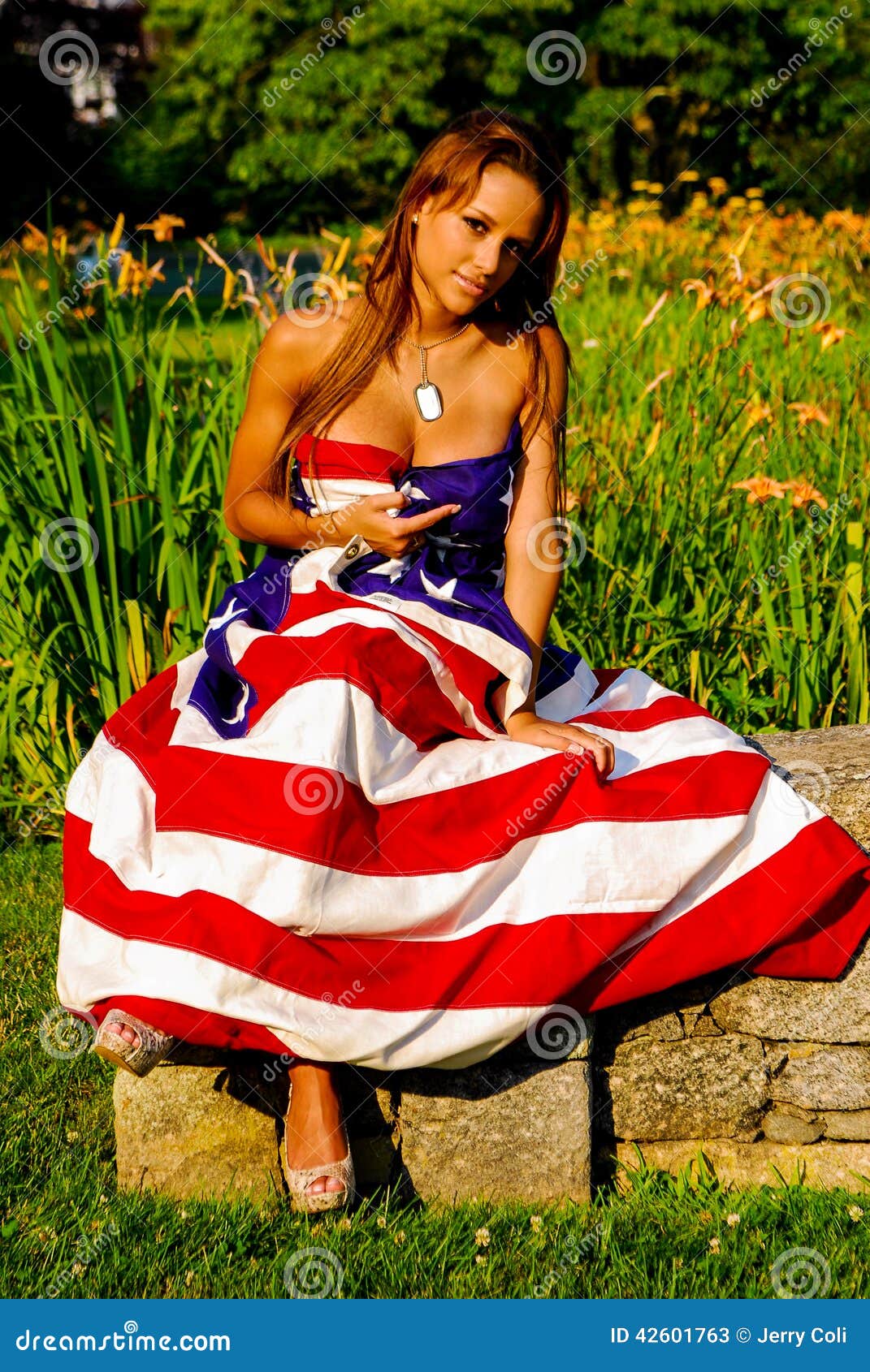 Beautiful model draped in the American Flag. Stars and Stripes forever as a beautiful model wears a flag.