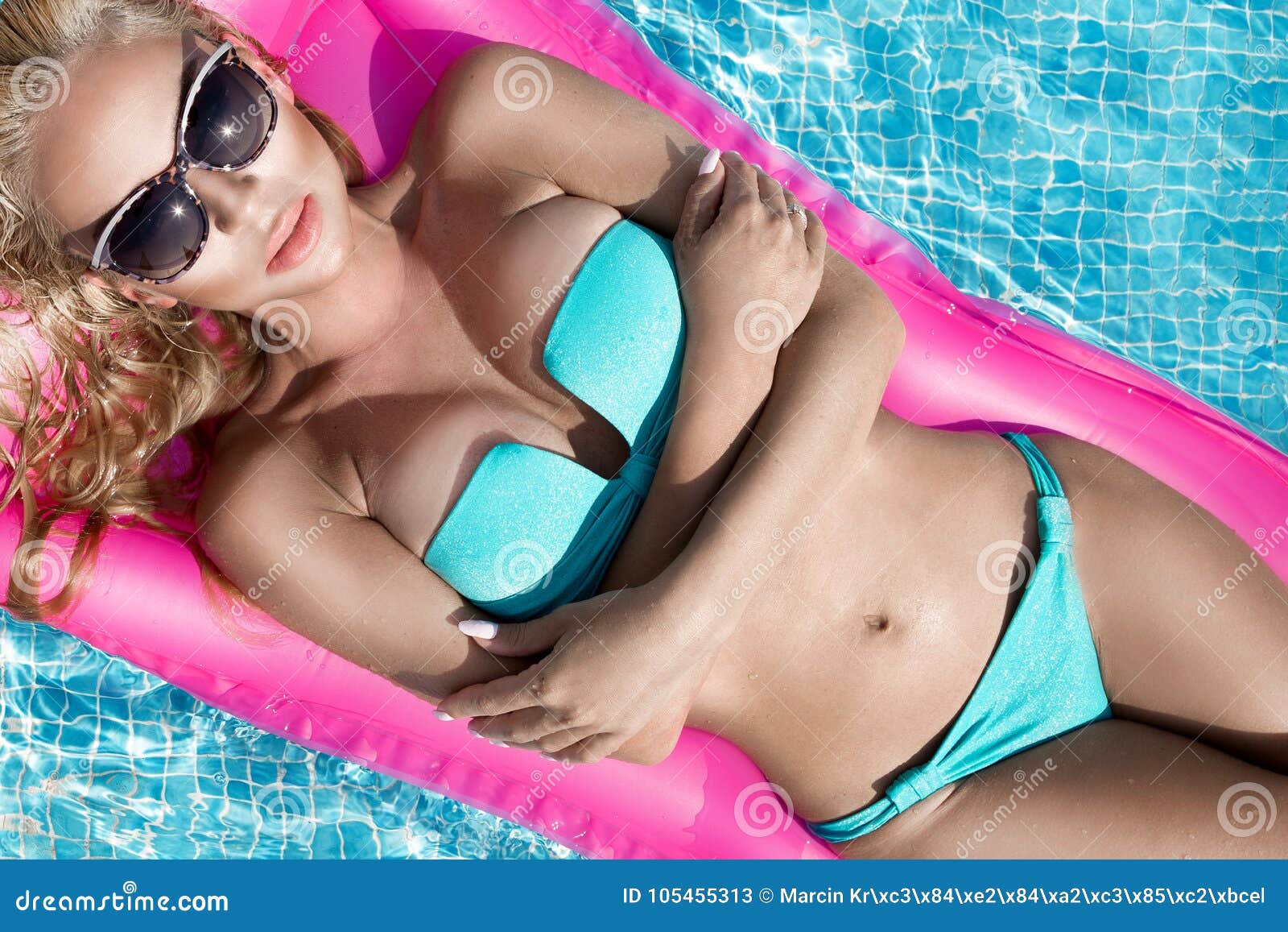 Beautiful Model Model with Long Blonde Wet Hairs, Sunglasses and Bikini Swims in the Pool on a Pink Mattress , Stock Image