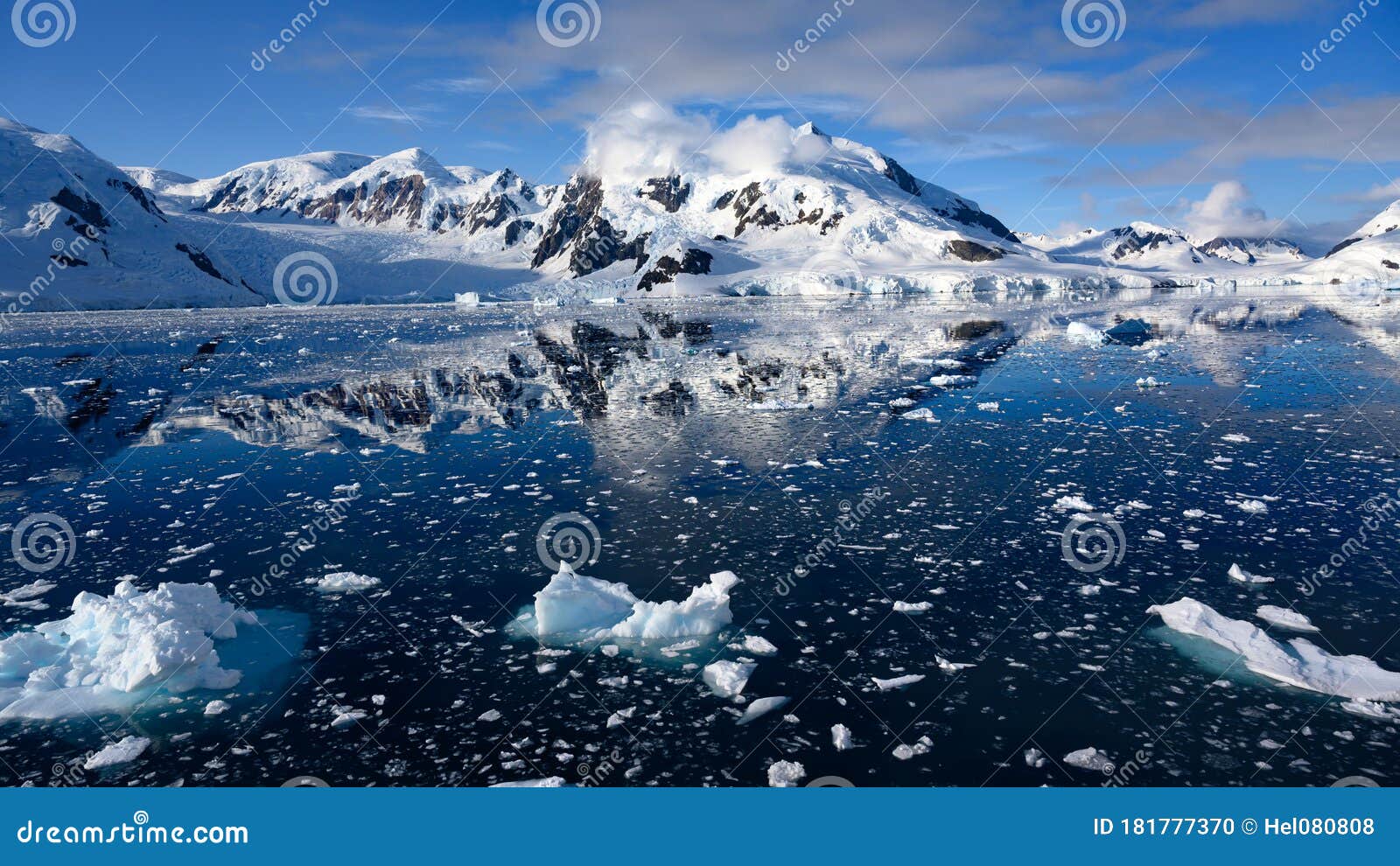 snowcapped mountains in beautiful landscape, reflecting in blue water, ice flows, lemaire channel near paradise bay, antarctica
