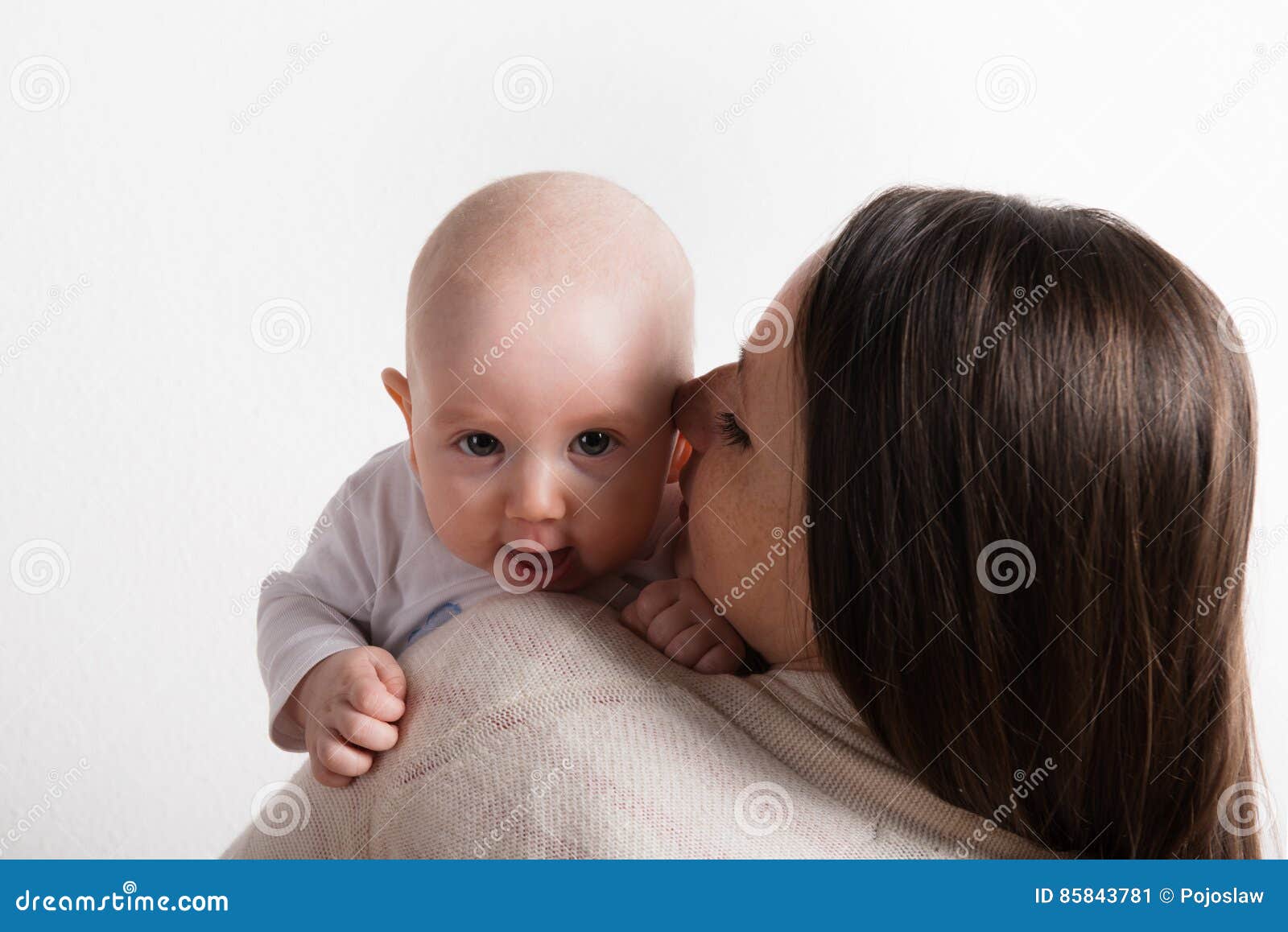 Beautiful Mother Holding Baby Son In Her Arms. Studio Shot 