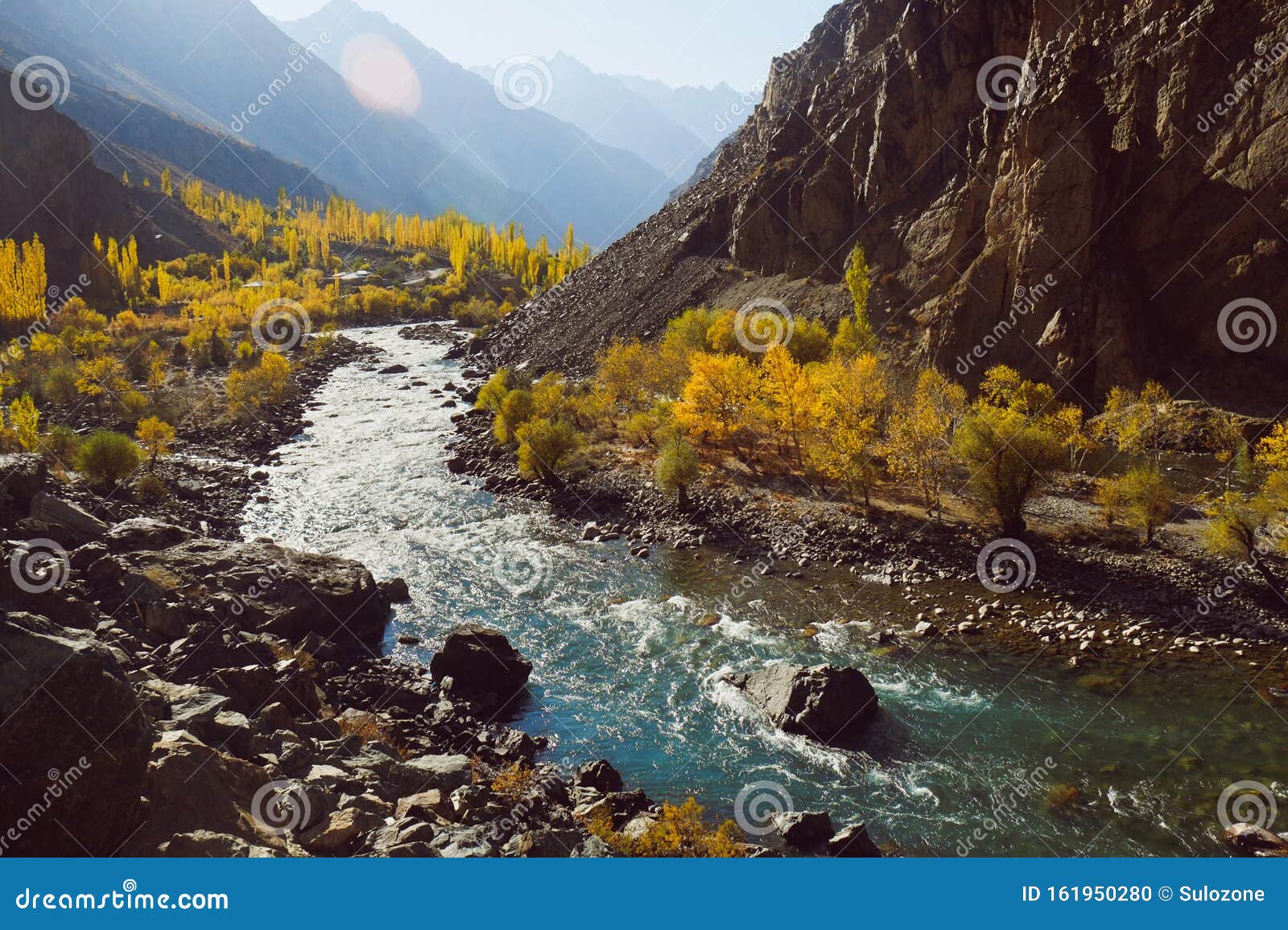 winding river flowing along valley in hindu kush mountain range. autumn season in pakistan