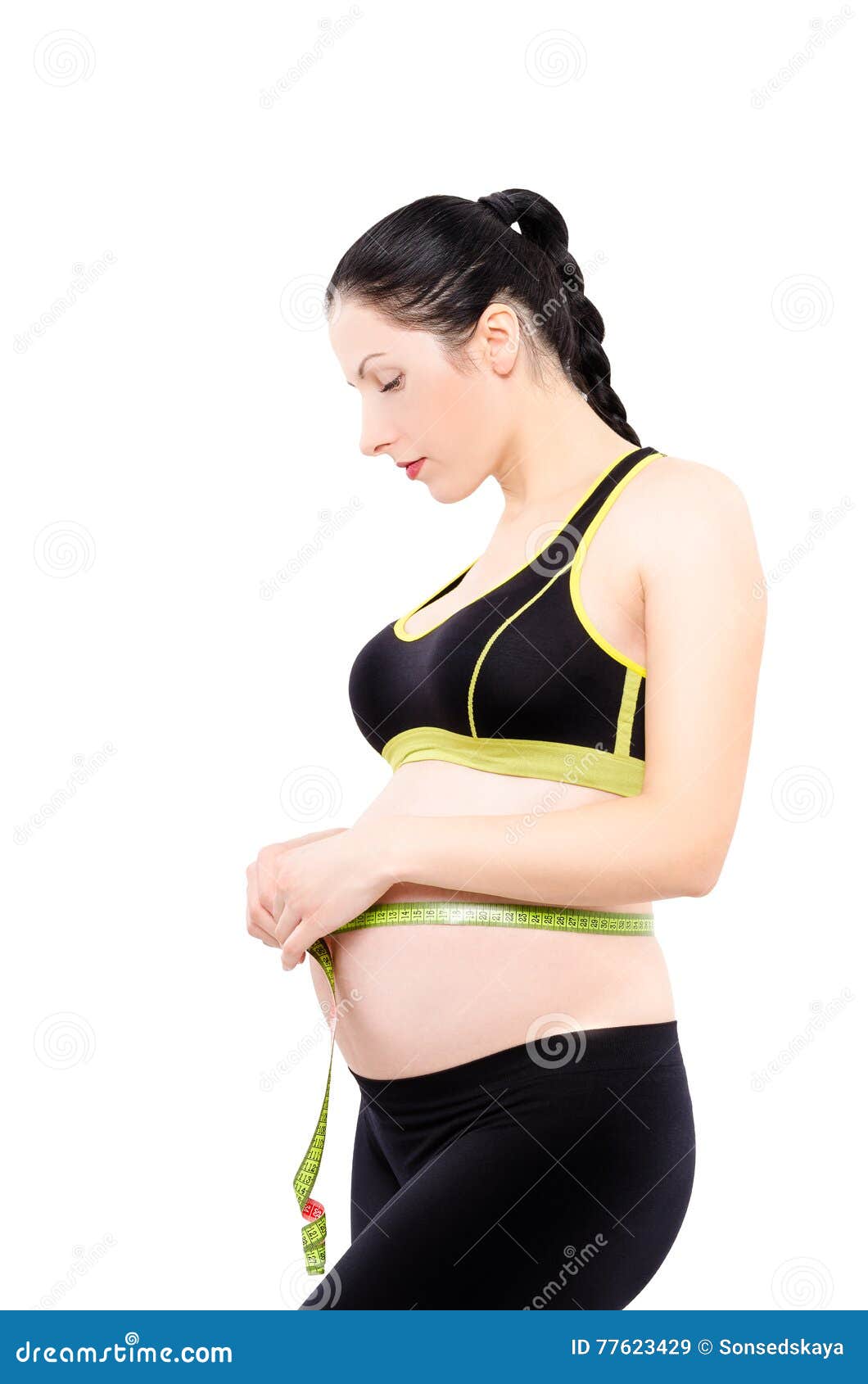 beautiful pregnant woman measures the abdominal circumference centimeter tape