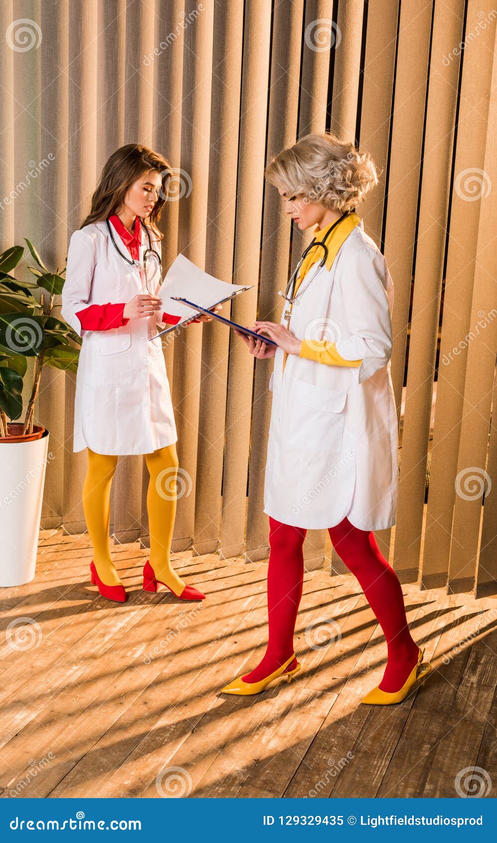 beautiful retro styled doctors looking at clipboards