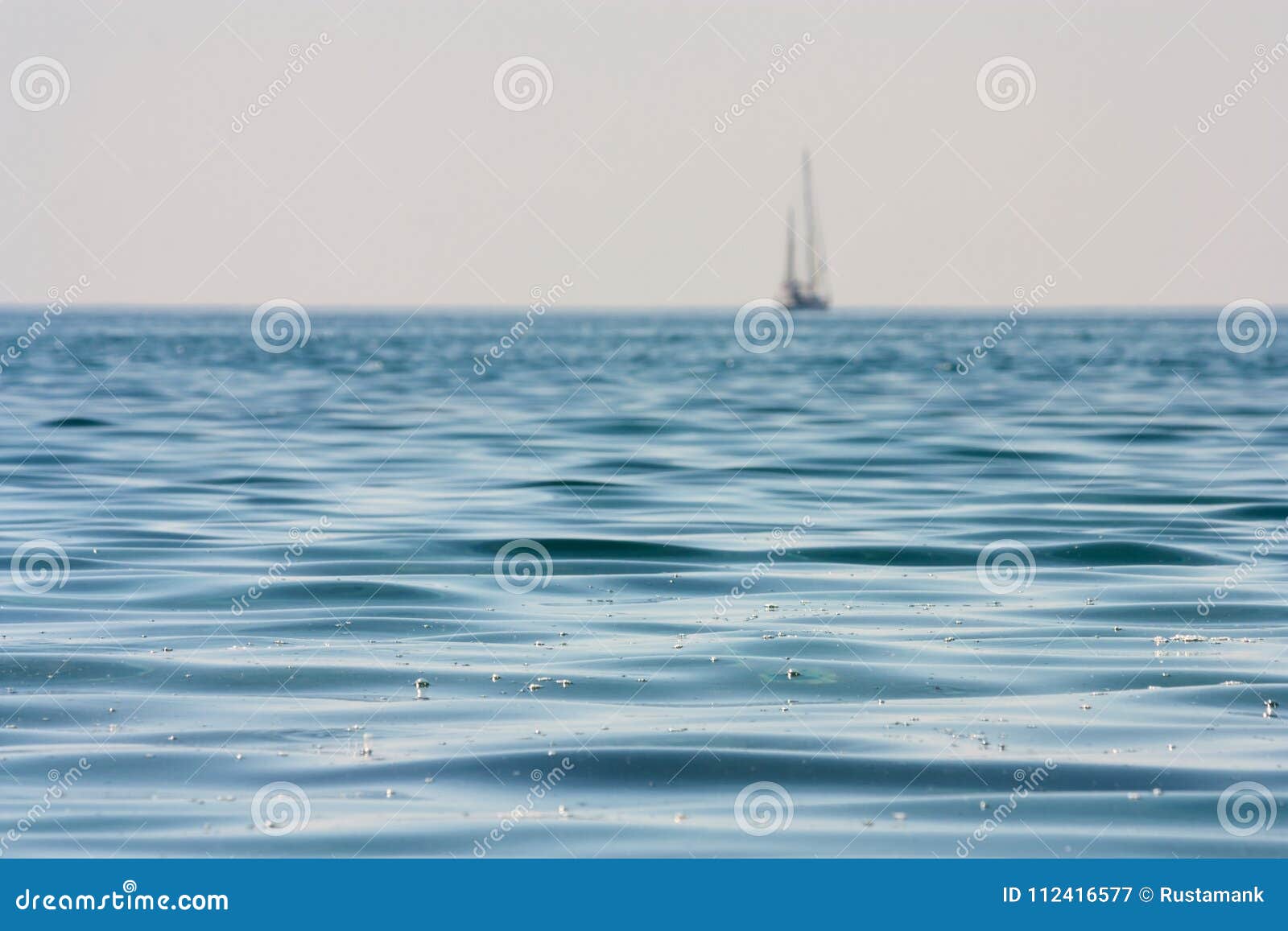 beautiful seascape - view of morning sea with a sailboat on horizon in the bay next to of ancient phaselis, coast of the mediterra