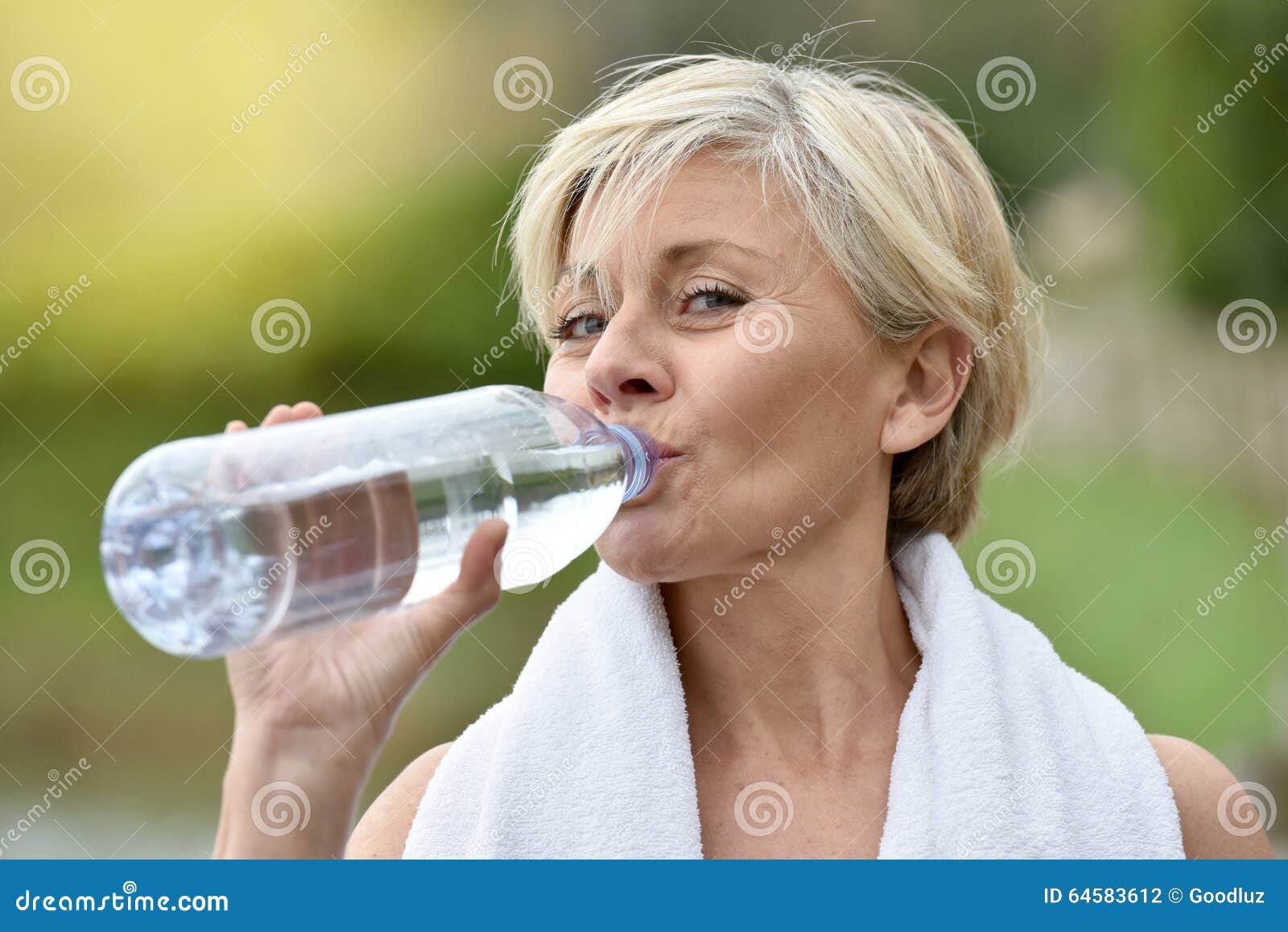 beautiful senior woman drinking water after excercising