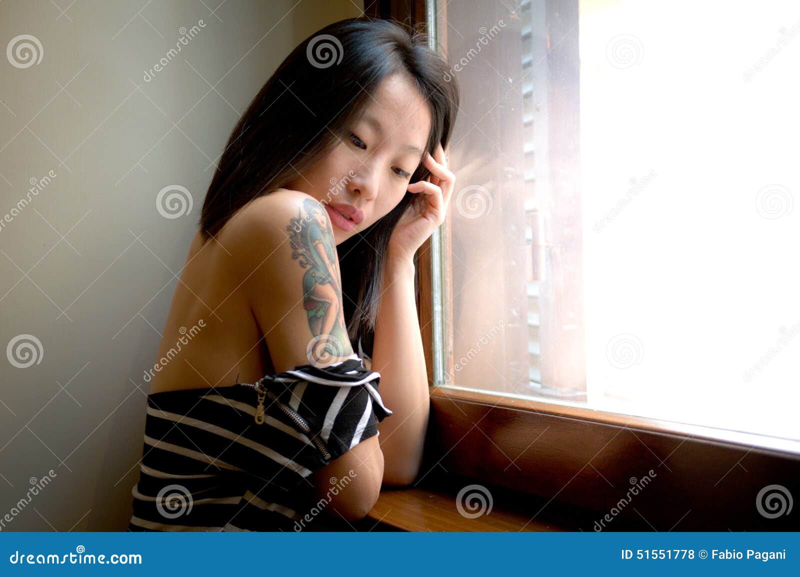 Beautiful Sensual Asian Woman Posing Thoughtful At Window Stock Photo