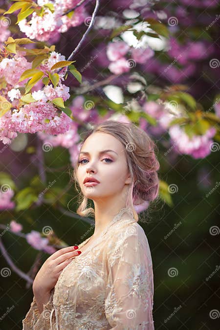 Beautiful Adult Girl Standing At Blossoming Tree In The Garden Stock