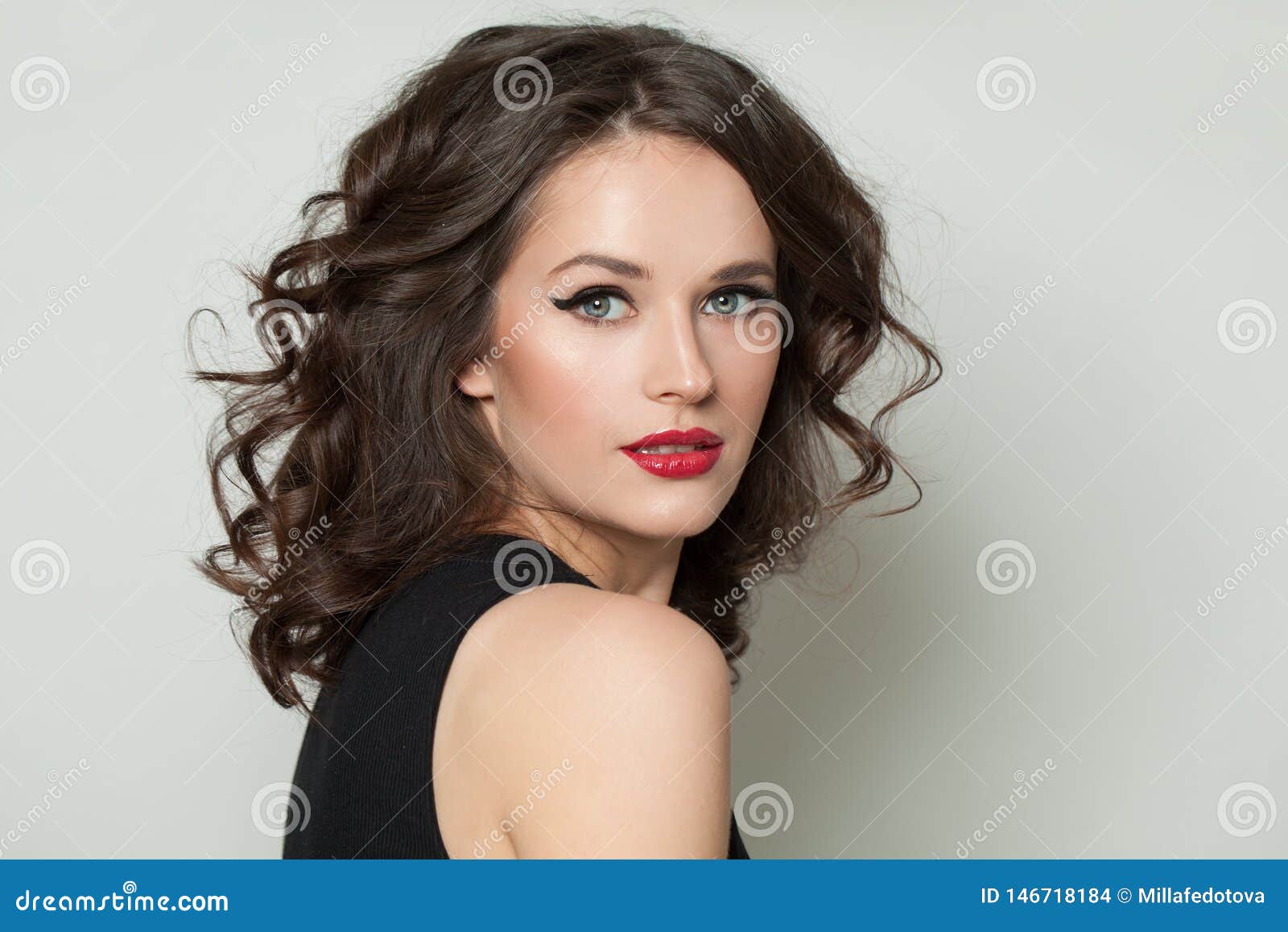 beautiful sexy woman looking at camera. pretty model with makeup and brown curly hair portrait