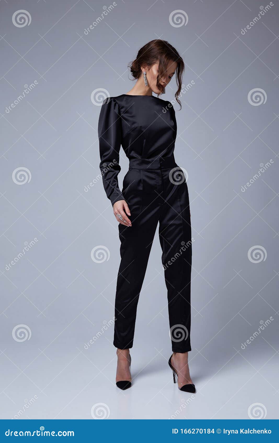 Beautiful young sexy woman with long brunette hair with bright evening make  up perfect summer tan thin figure wear black suit jacket pants high heels  shoes perfect body shape accessory businesswoman. Stock