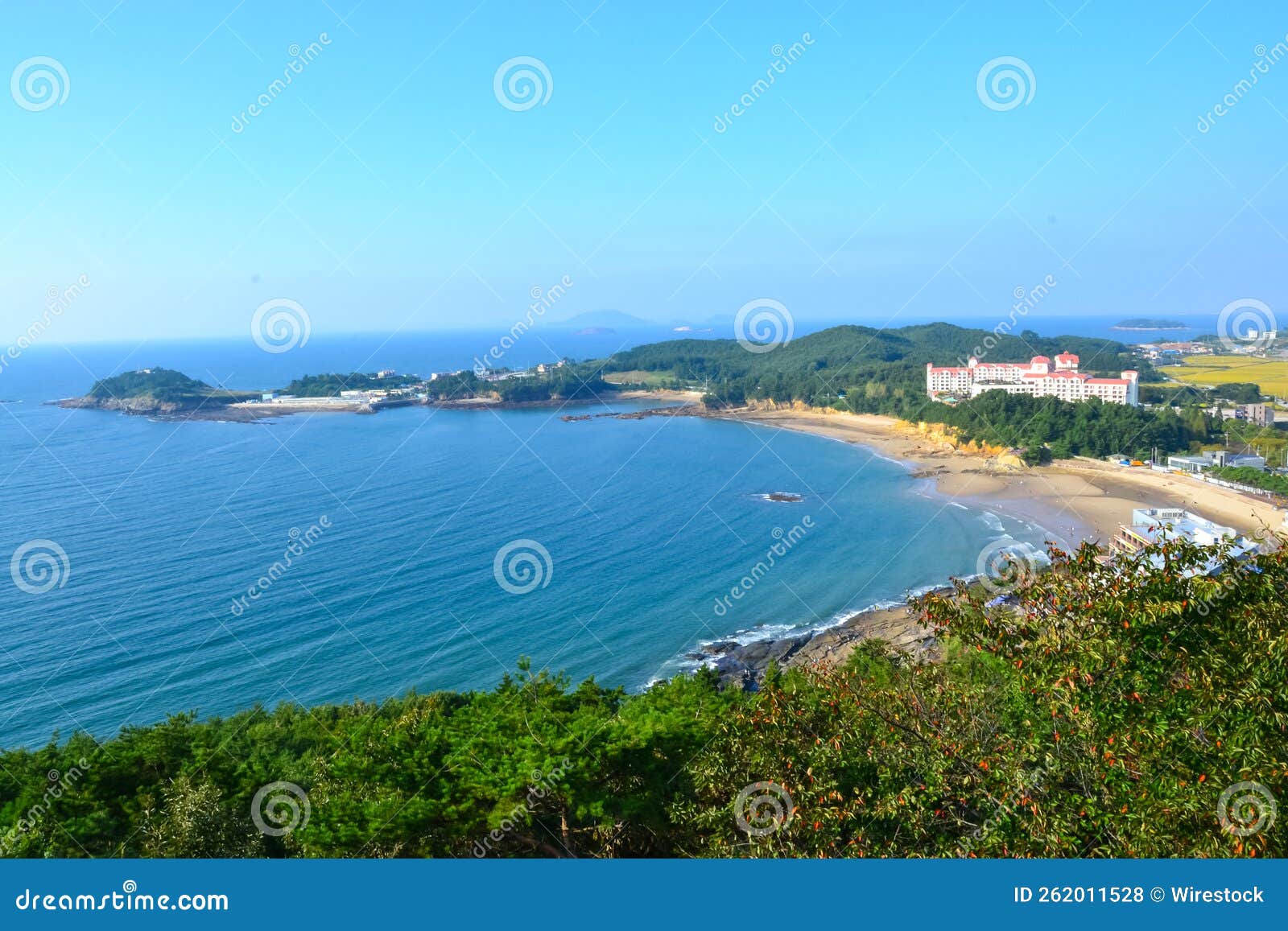 beautiful shot of the beach and a white building on the hill in byeonsan-bando national park