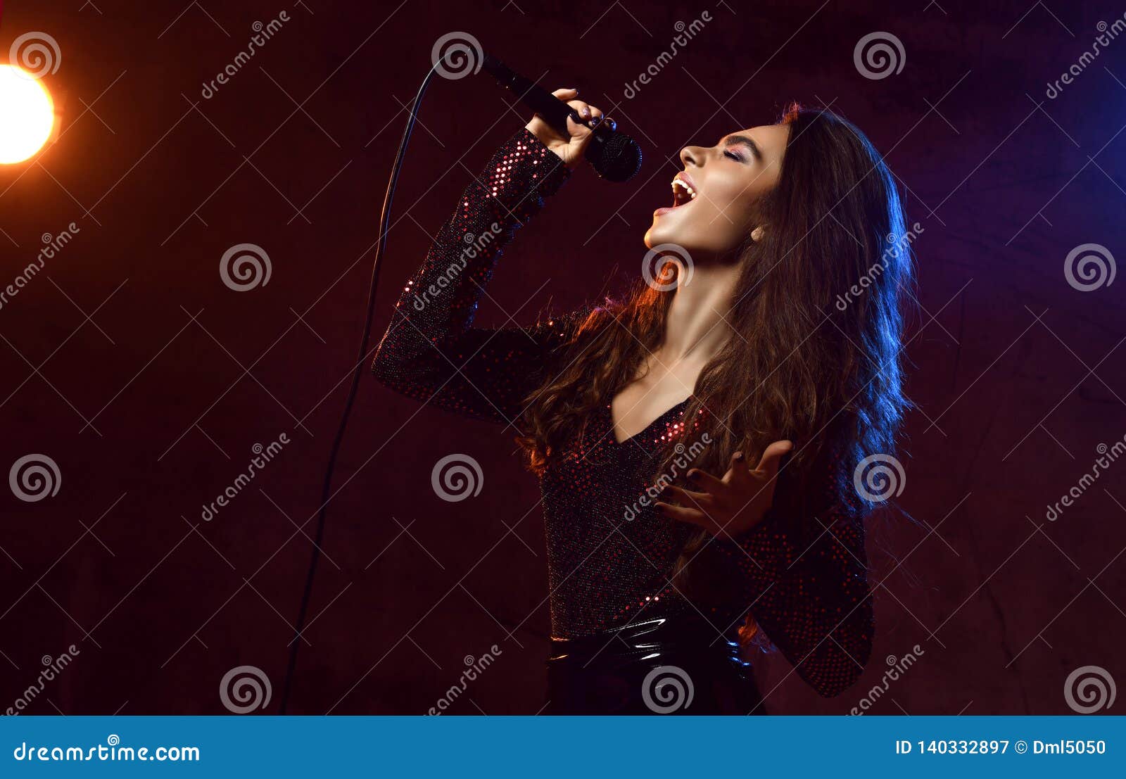 beautiful singing girl curly afro hair. beauty woman singer sing with microphone karaoke song on stage smoke, spotlights