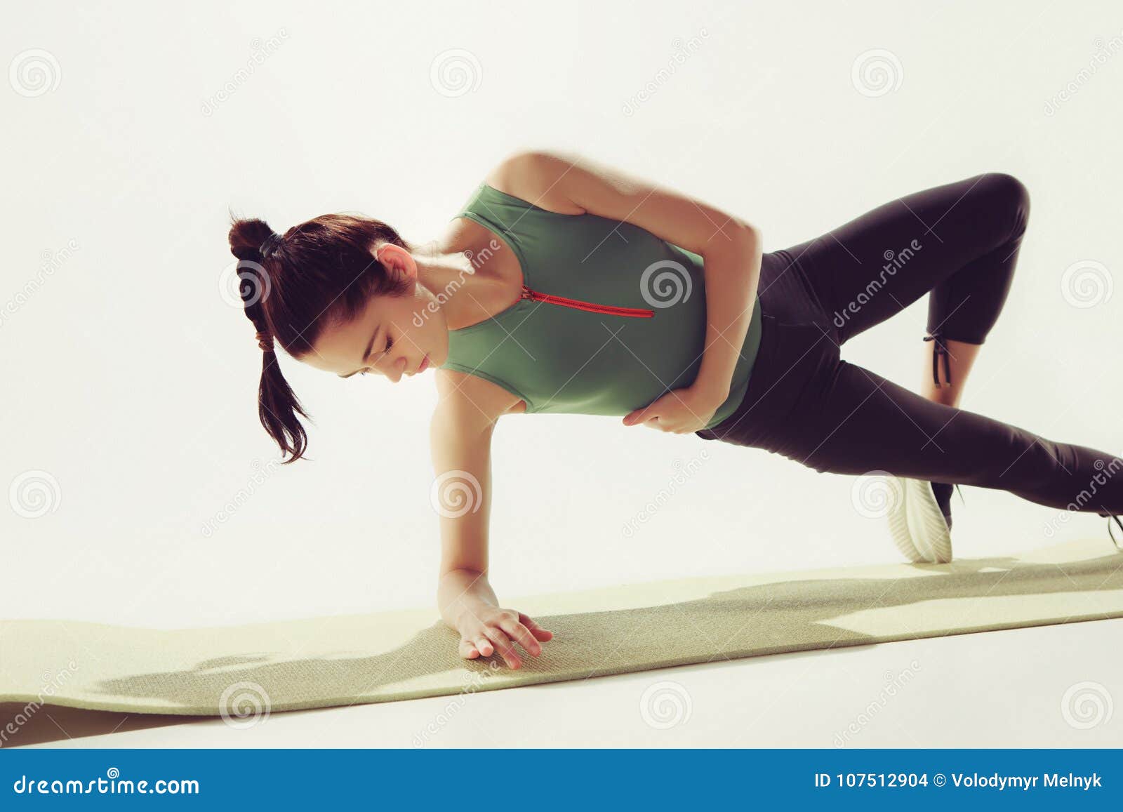 Beautiful Slim Brunette Doing Some Stretching Exercises In A Gym Stock