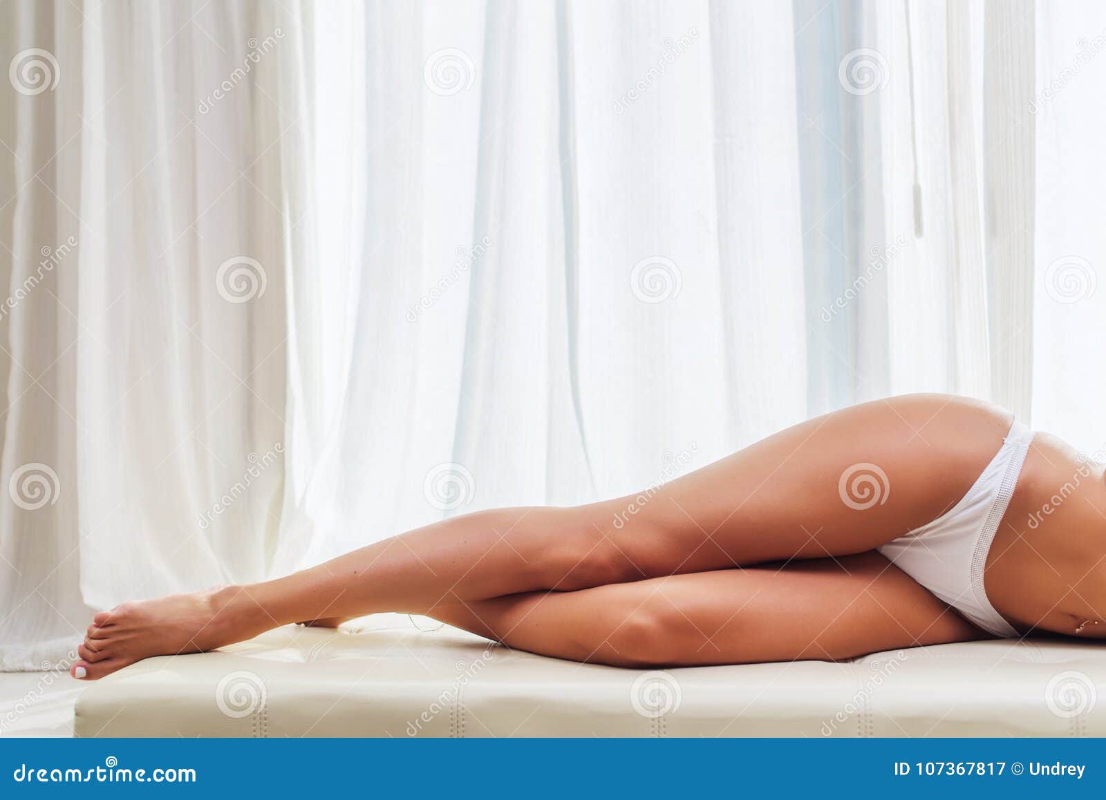 Foto de Body Beauty, Sexy Woman in Cotton Underwear Lying Down on Side,  Slim Girl Isolated over White Background do Stock