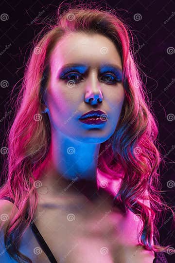 Beautiful Slim Busty Blonde Girl Wearing Black Bodysuit Lit Up In Pink And Blue Light Close Up