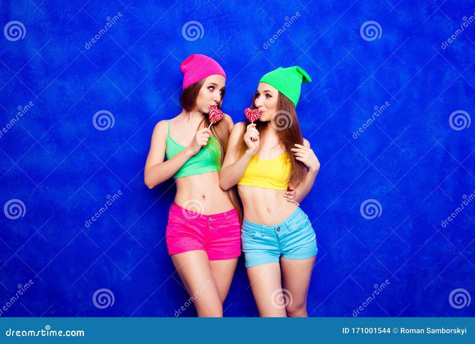 Beautiful Slim Sisters Licking Lollipops on Blue Background Stock Photo -  Image of family, holding: 171001544