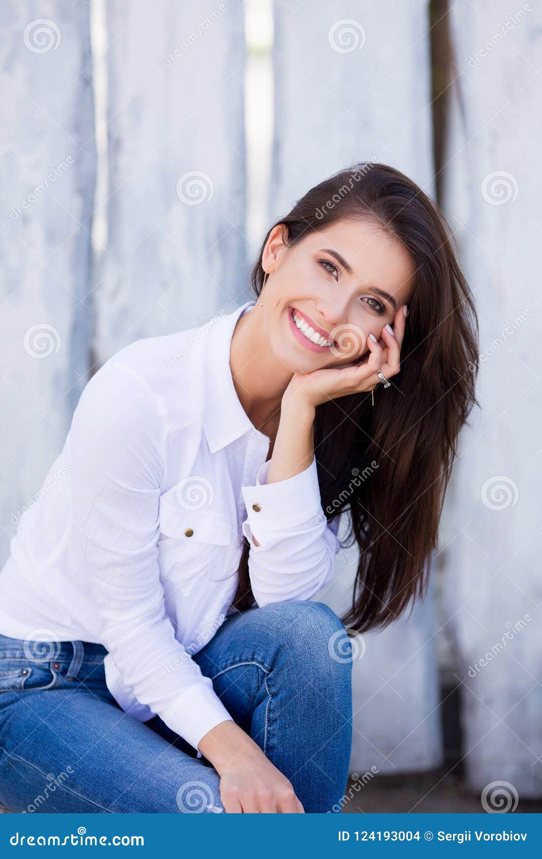 Beautiful brunette girl in a gray turtleneck and blue denim shorts is  zipping her special sports vest while posing sideways on a pier of the  coastal z Stock Photo - Alamy