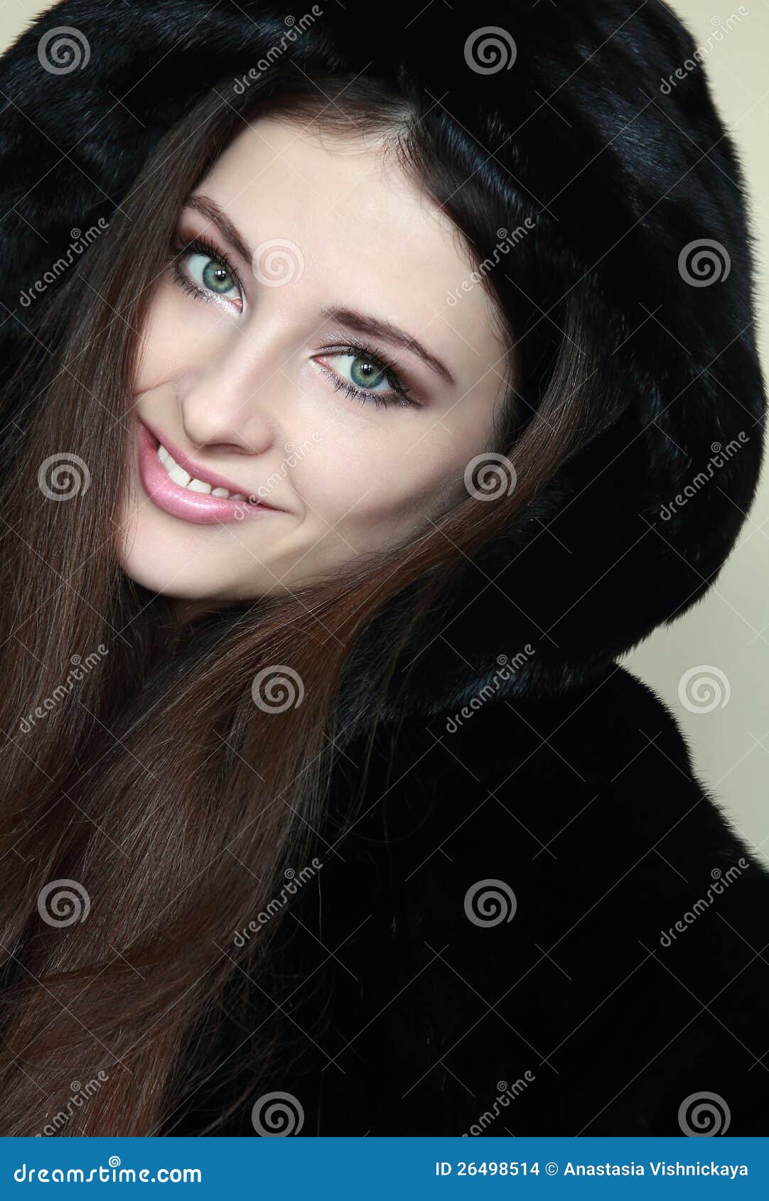 Beautiful smiling woman in fur hood coat looking happy. Closeup portrait