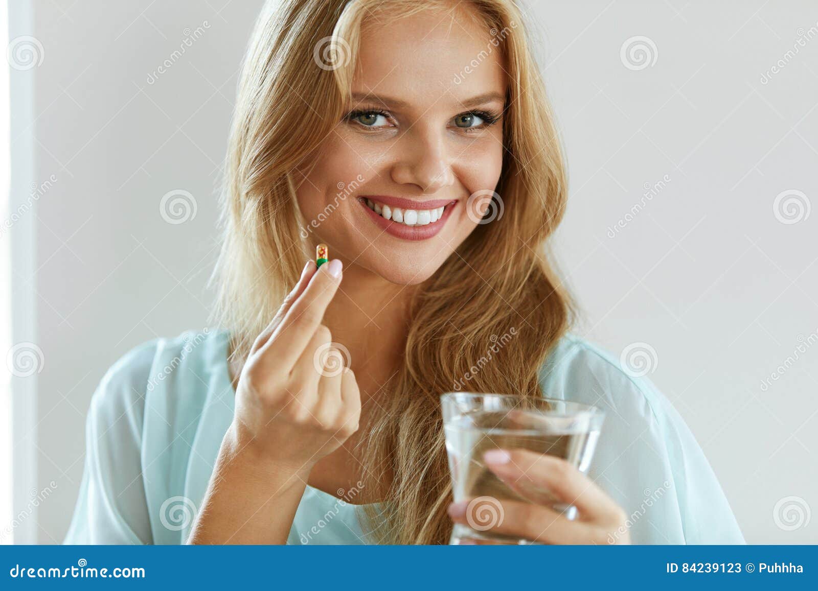 beautiful smiling woman taking vitamin pill. dietary supplement