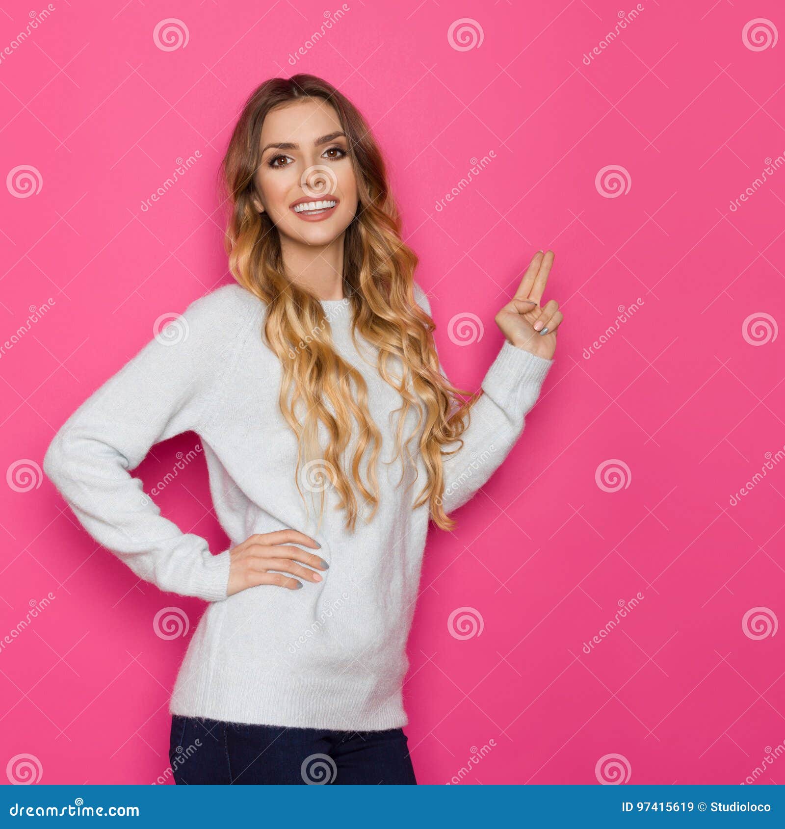 Beautiful Smiling Young Woman Is Pointing With Two Fingers Stock Image 